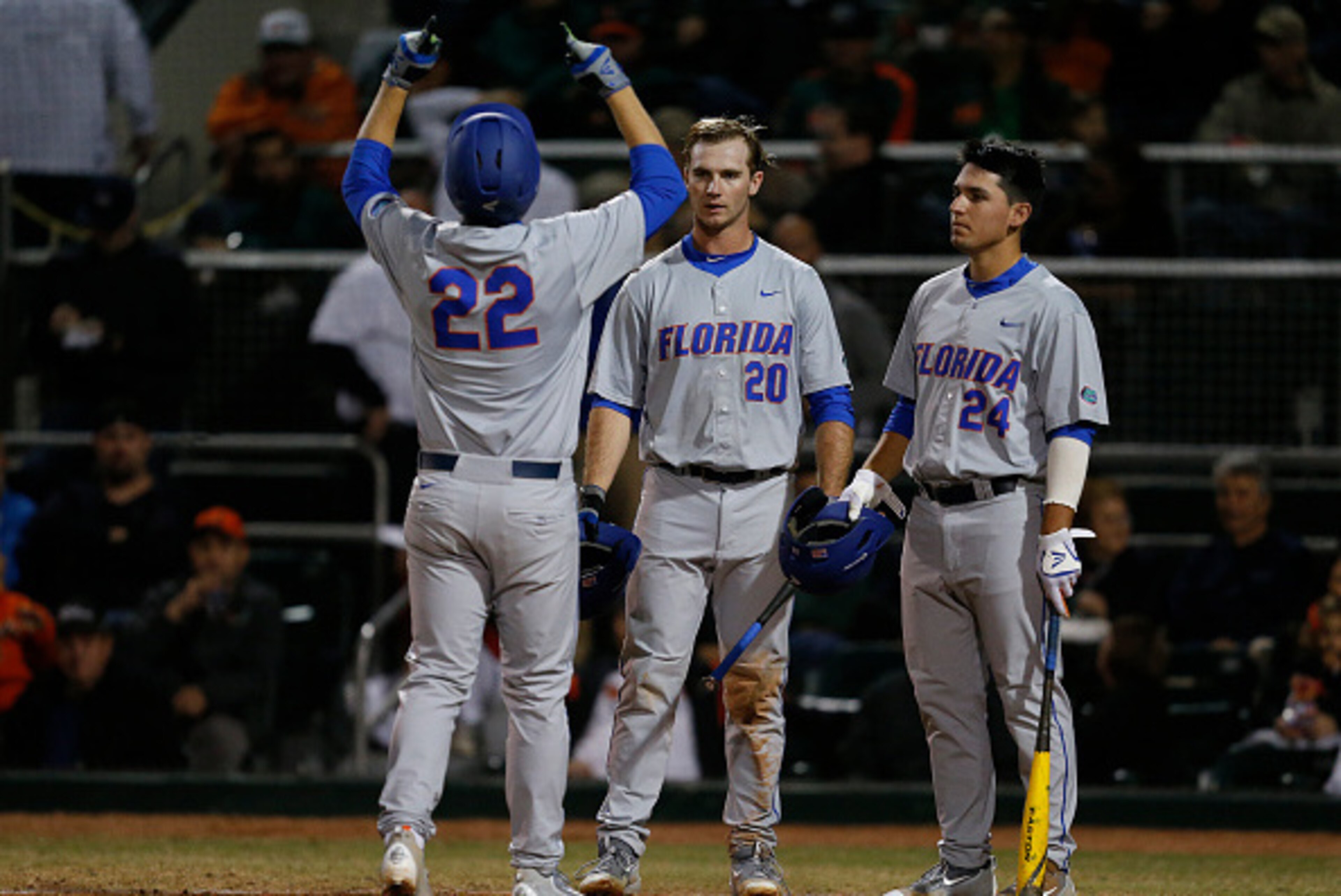 CORAL GABLES, FL - FEBRUARY 26: JJ Schwarz #22 is congratulated by Peter Alonso #20 and Jeremy Vasquez #24 of the Florida Gators after hitting a solo home run against the Miami Hurricanes on February 26, 2016 at Alex Rodriguez Park at Mark Light Field in 