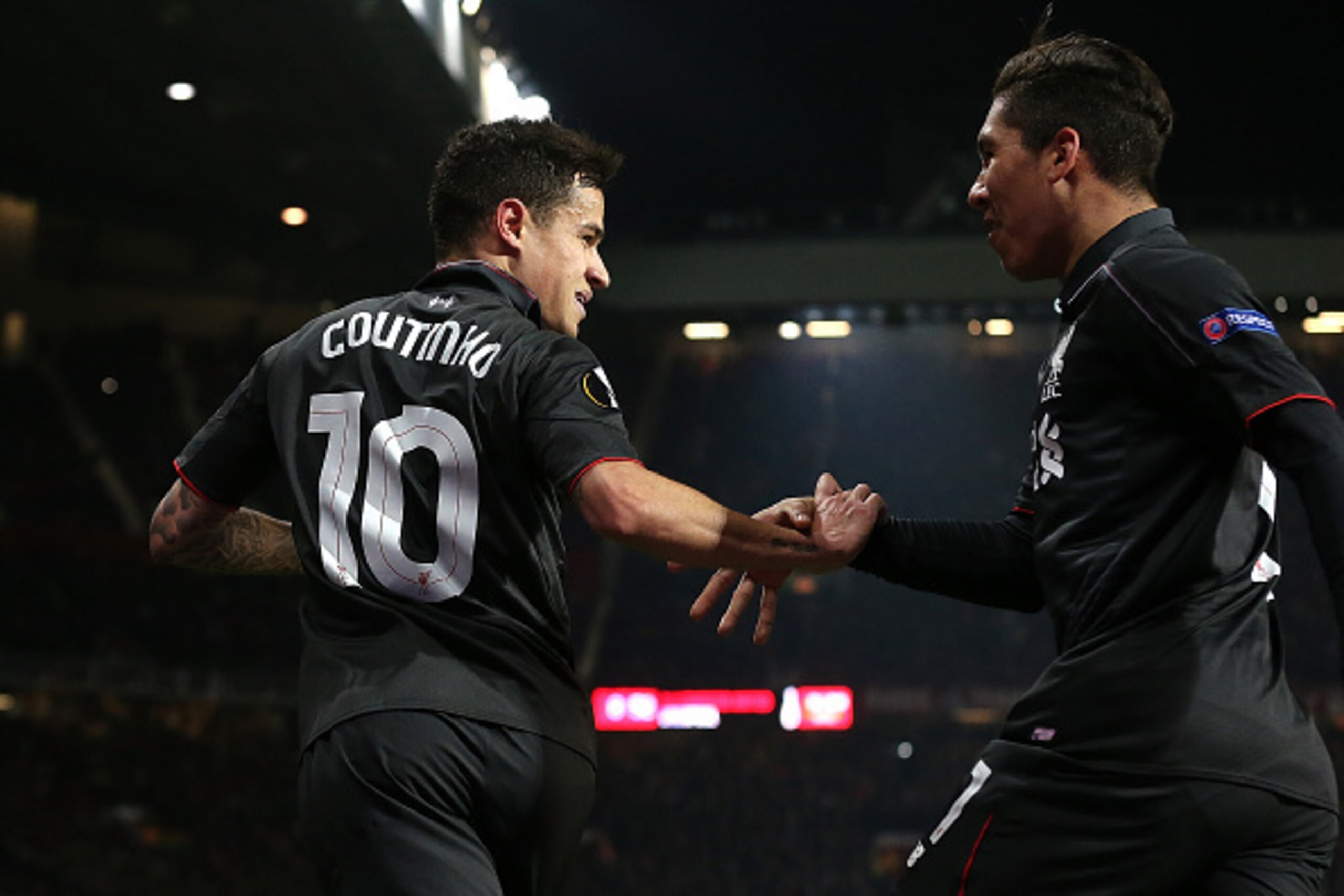 MANCHESTER, ENGLAND - MARCH 17:  Philippe Coutinho of Liverpool celebrates scoring his team's first goal with team-mate Roberto Firmino (R) during the UEFA Europa League Round of 16 Second Leg match between Manchester United and Liverpool at Old Trafford 