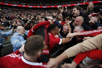 Manchester United's French striker Anthony Martial (C) celebrates in the crowd after scoring their second goal during the English FA Cup semi-final football match between Everton and Manchester United at Wembley Stadium in London on April 23, 2016. / AFP 