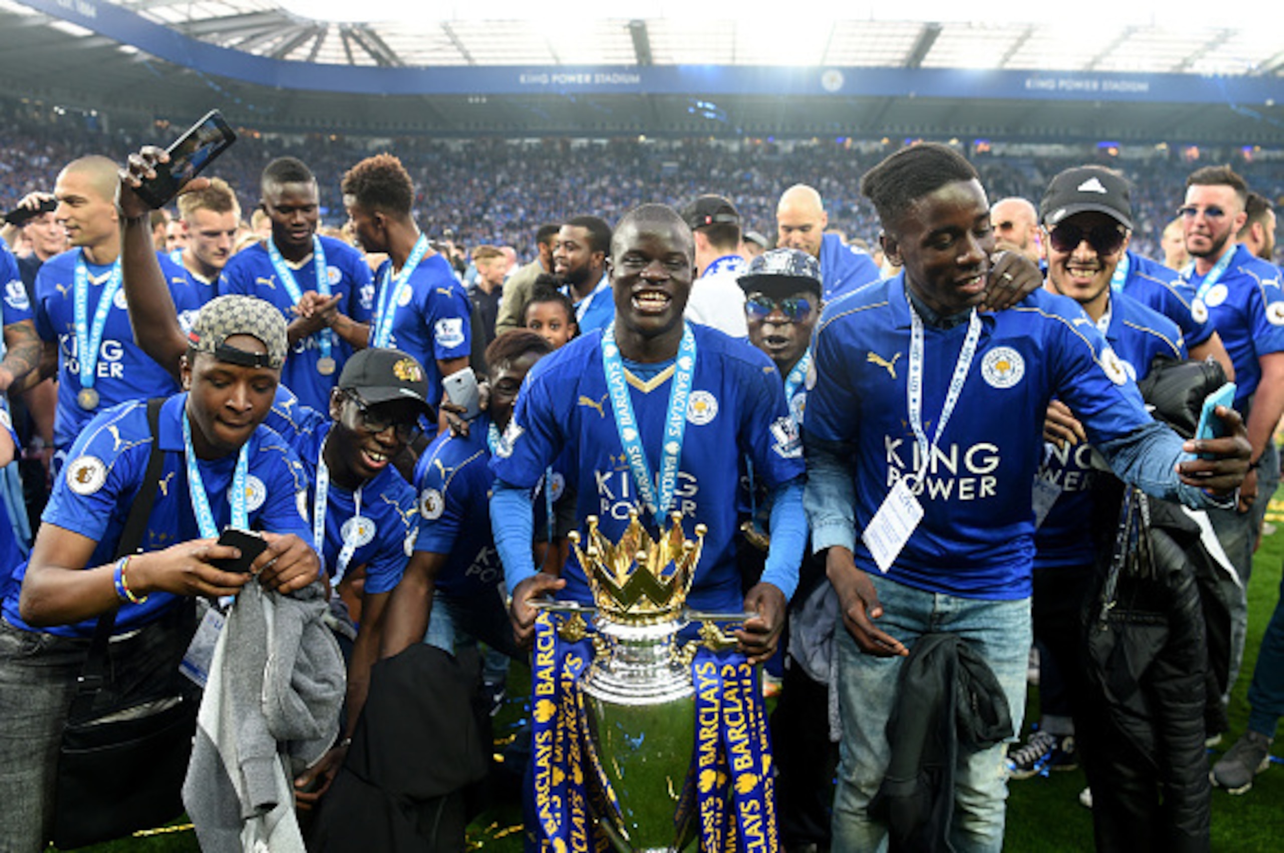 LEICESTER, ENGLAND - MAY 07: Ngolo Kante of Leicester City poses with the Premier League Trophy with his family as players and staffs celebrate the season champion after the Barclays Premier League match between Leicester City and Everton at The King Pow LEICESTER, ENGLAND - MAY 07: Ngolo Kante of Leicester City poses with the Premier League Trophy with his family as players and staffs celebrate the season champion after the Barclays Premier League match between Leicester City and Everton at The King Pow