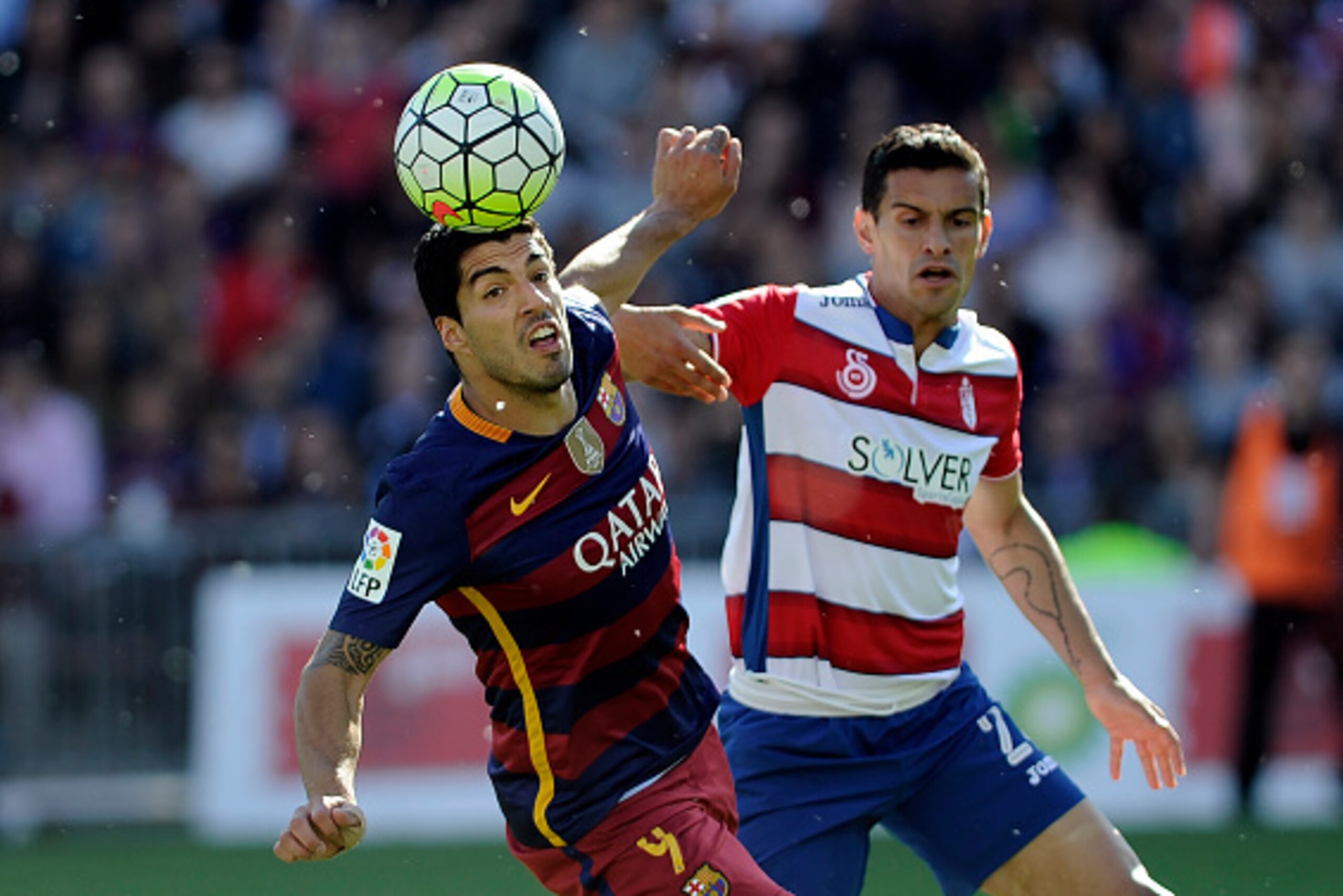 Barcelona's Uruguayan forward Luis Suarez (L) vies for the ball with Granada's Gabonese defender Yrondu Musavu-King during the Spanish league football match Granada CF vs FC Barcelona at Nuevo Los Carmenes stadium in Granada on May 14, 2016. / AFP / CRIST