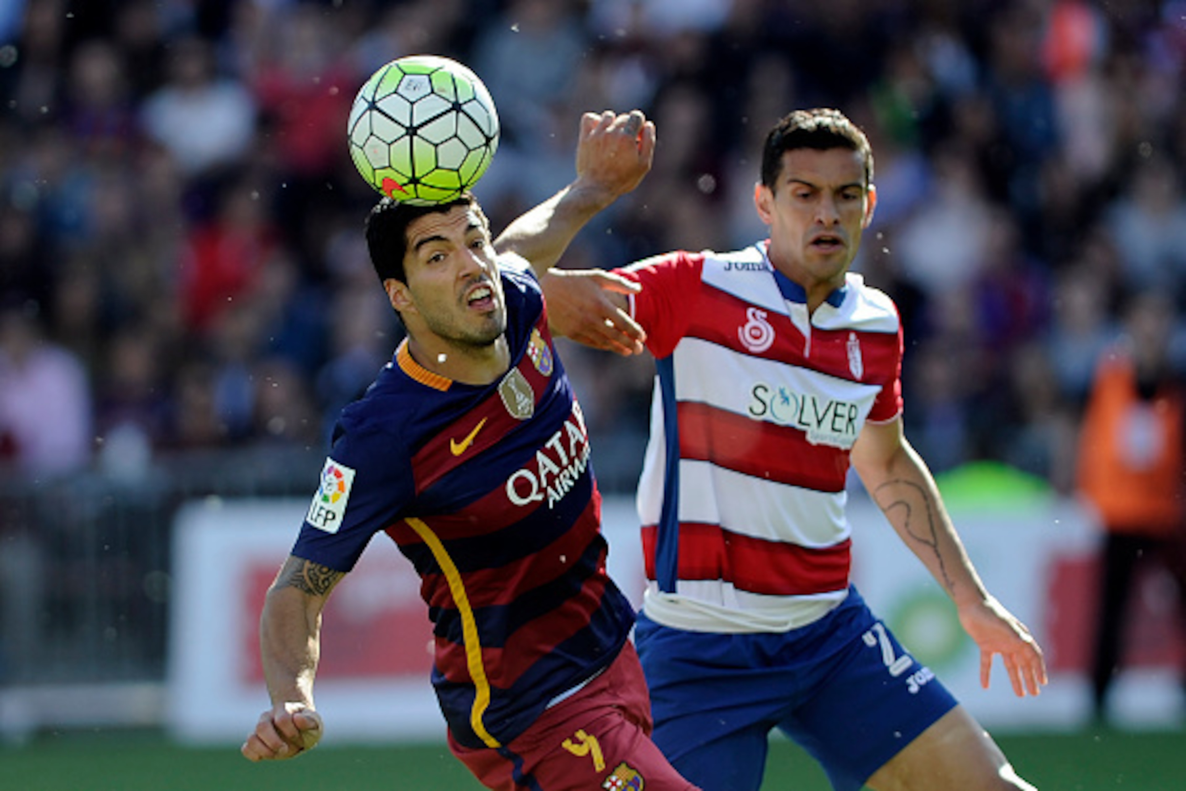 Barcelona's Uruguayan forward Luis Suarez (L) vies for the ball with Granada's Gabonese defender Yrondu Musavu-King during the Spanish league football match Granada CF vs FC Barcelona at Nuevo Los Carmenes stadium in Granada on May 14, 2016. / AFP / CRIST