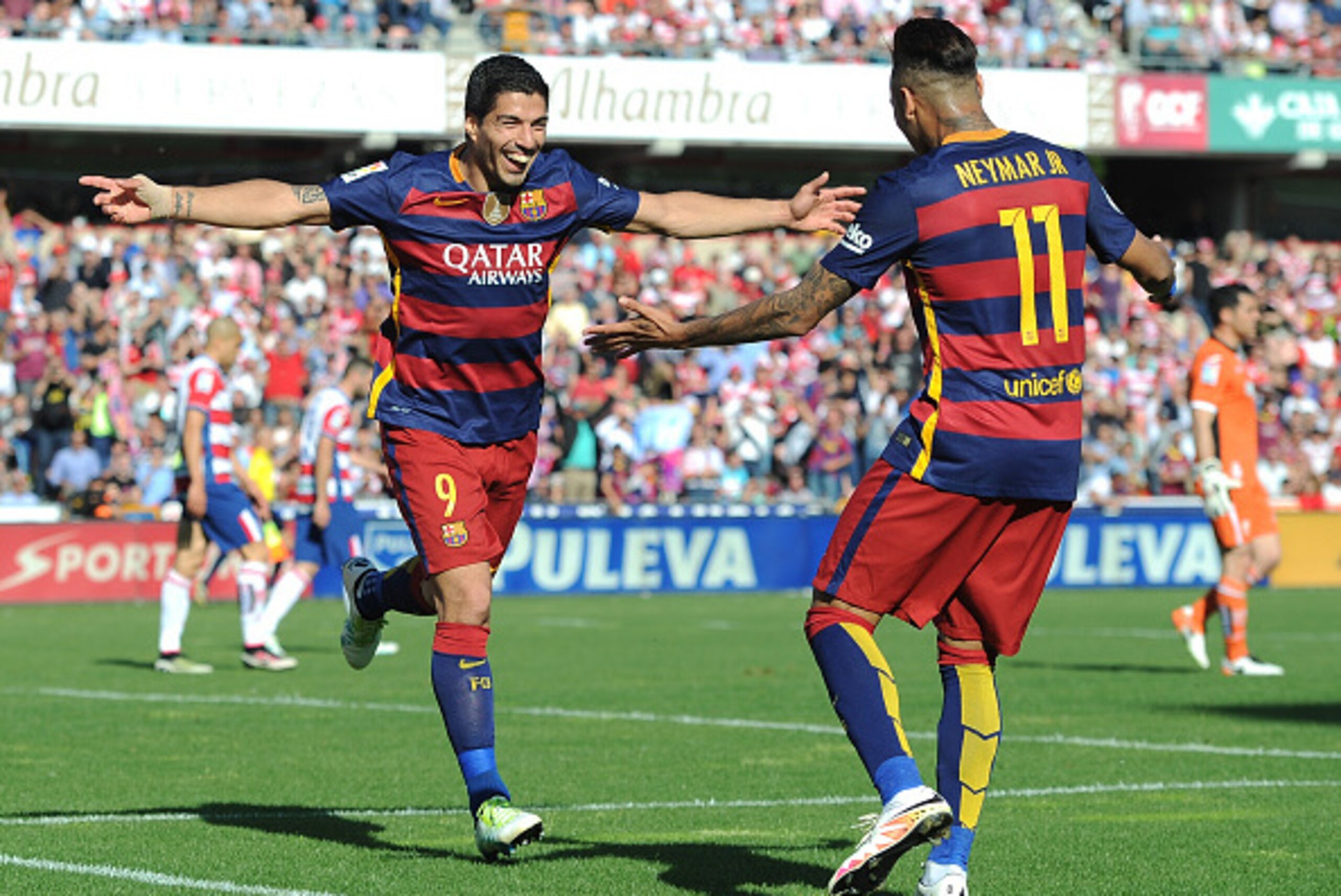 GRANADA, SPAIN - MAY 14: Luis Suarez (L) of Barcelona celebrates scoring his team's third goal and his hat trick goal with his team mate Meymar (R) during the La Liga match between Granada and Barcelona at Estadio Nuevo Los Carmenes on May 14, 2016 in Gra