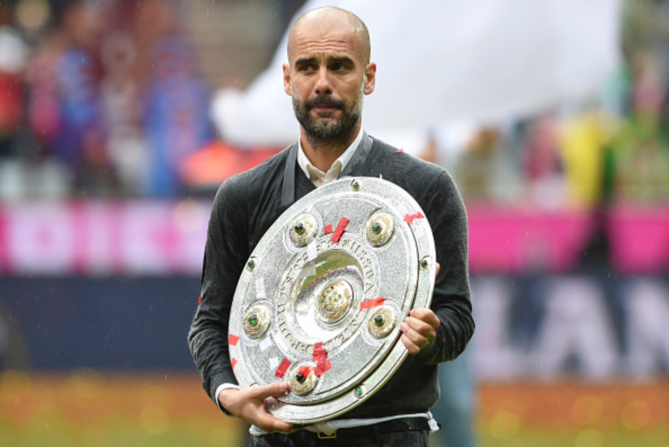 Bayern Munich's Spanish head coach Pep Guardiola celebrates with Bundesliga trophy after the German first division Bundesliga football match between FC Bayern Munich and Hannover 96 in Munich, southern Germany, on May 14, 2016. / AFP / Christof STACHE / R