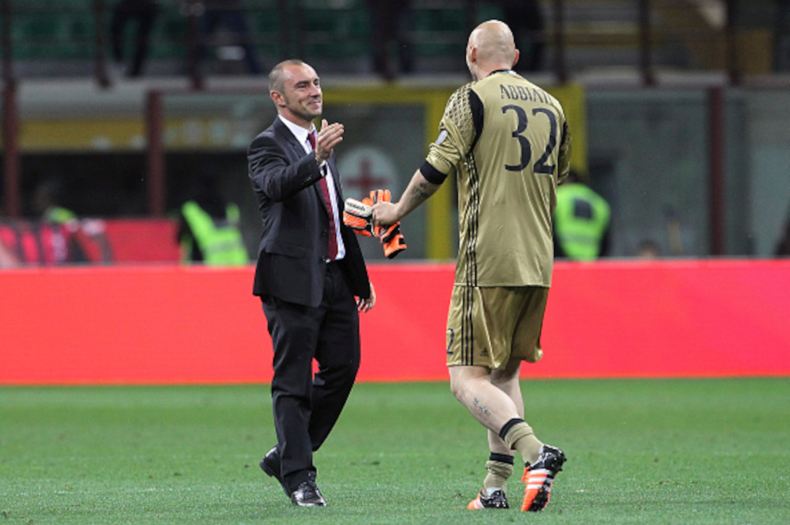 MILAN, ITALY - MAY 14:  Christian Abbiati (R) of AC Milan shakes hands with his coach coach Cristian Brocchi (L) at the end of the Serie A match between AC Milan and AS Roma at Stadio Giuseppe Meazza on May 14, 2016 in Milan, Italy.  (Photo by Marco Luzza