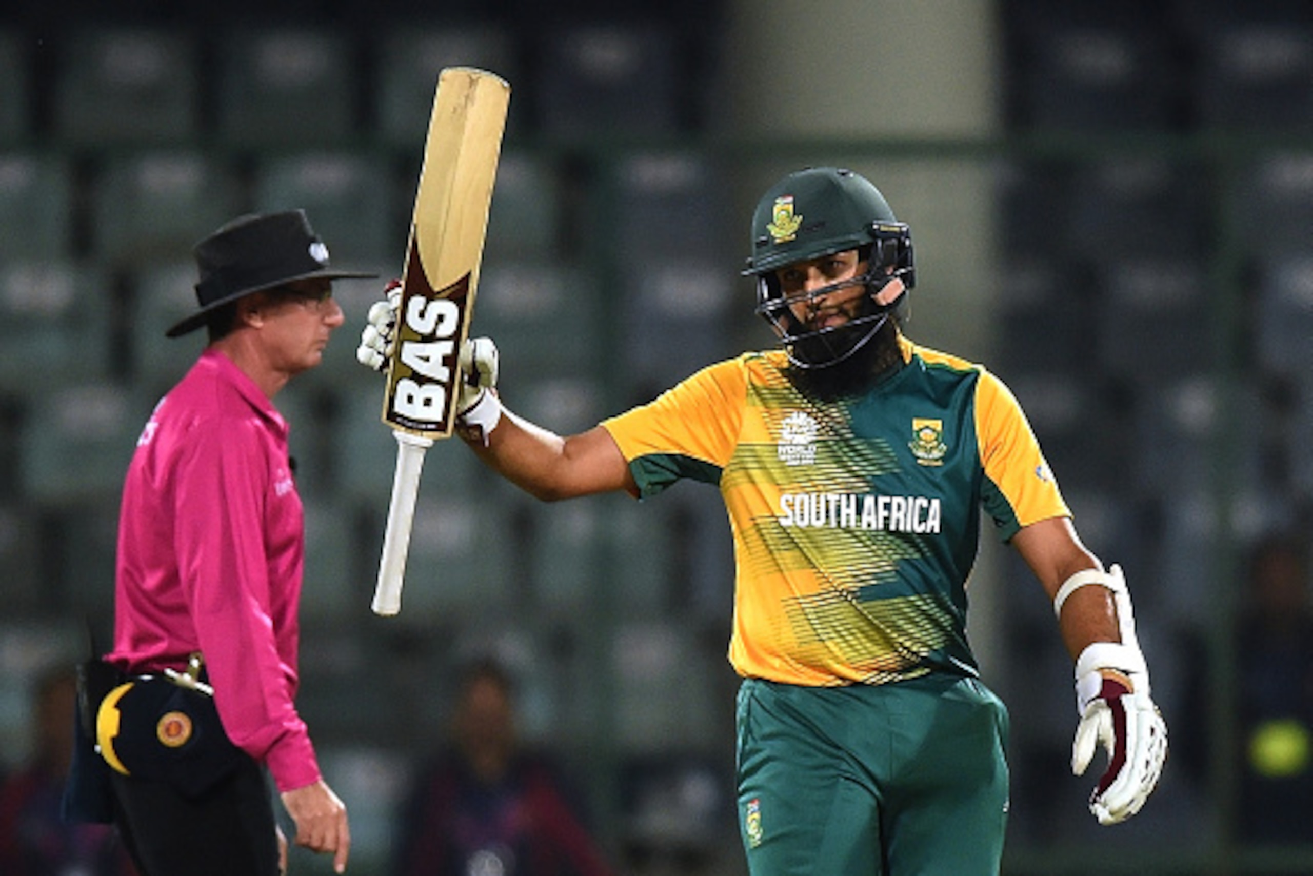 (FILES) In this photograph taken on March 28, 2016, South Africa's Hashim Amla (R) raises his bat after scoring a half-century (50 runs) during the World T20 cricket tournament match between South Africa and Sri Lanka at Feroz Shah Kotla cricket ground in