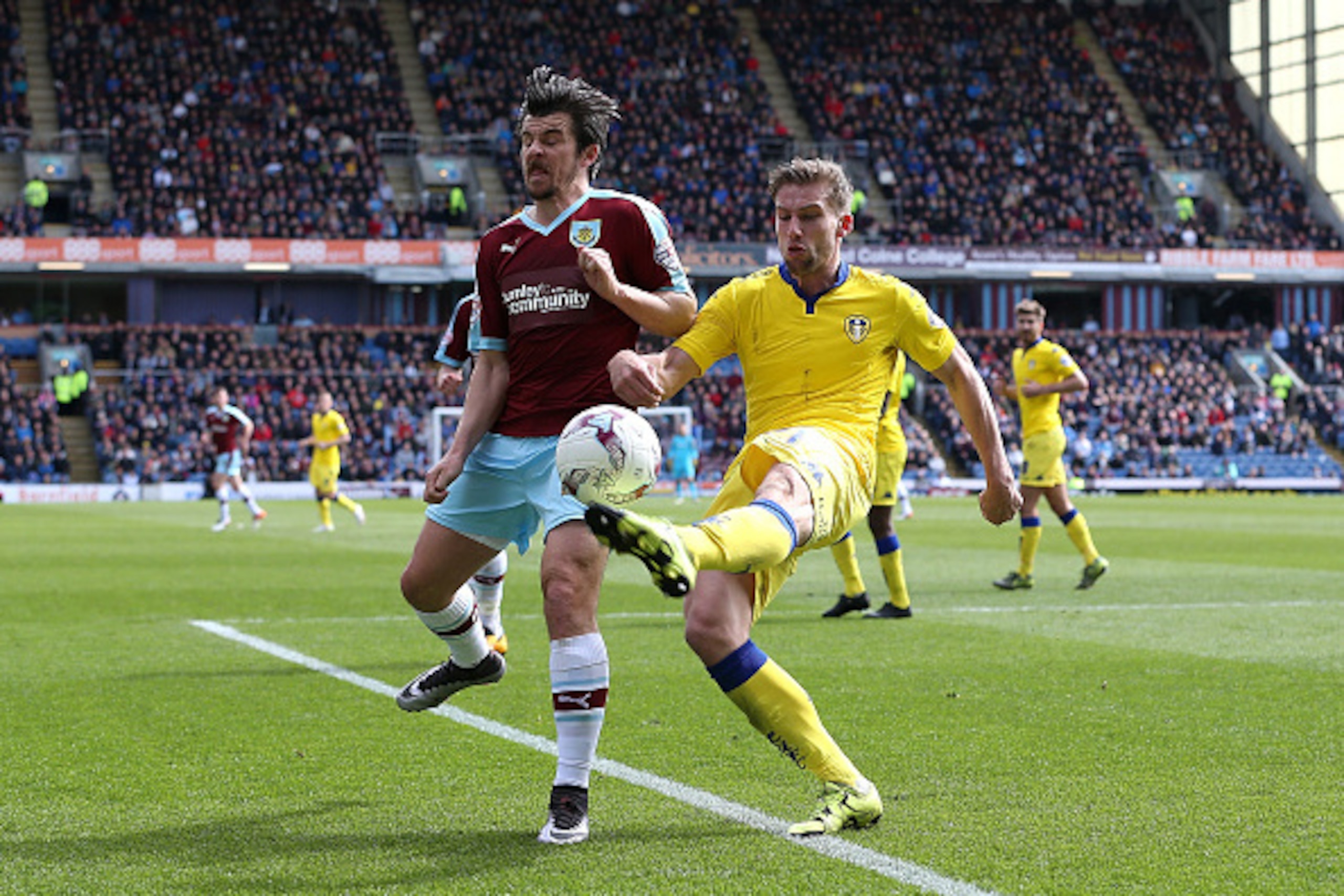 BURNLEY, ENGLAND - APRIL 09:  Charlie Taylor of Leeds clears the ball from Joey Barton of Burnley during the Sky Bet Championship match between Burnley and Leeds United at Turf Moor on April 9, 2016 in Burnley, United Kingdom.  (Photo by Jan Kruger/Getty 