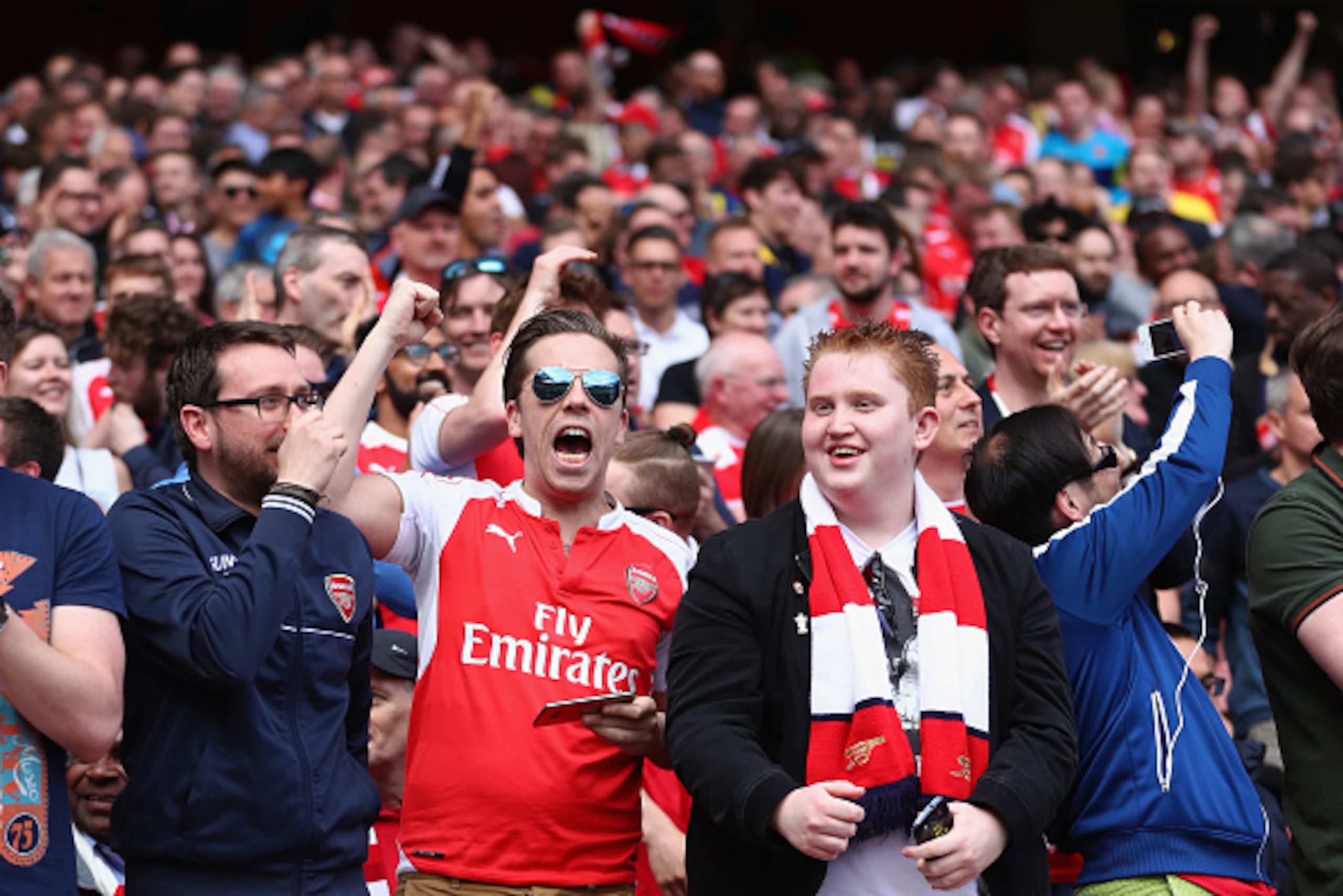 LONDON, ENGLAND - MAY 15:  Arsenal fans celebrate after hearing the Newcastle score against Tottenham Hotspur during the Barclays Premier League match between Arsenal and Aston Villa at the Emirates Stadium on May 15, 2016 in London, England.  (Photo by J