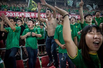 BEIJING, CHINA - JUNE 28: (CHINA OUT) Ultra supporters and fans of the Beijing Guoan FC celebrate together after a goal against Chongcing Lifan FC during their Chinese Super League match on June 28, 2015 in Beijing, China. There are growing legions of ard