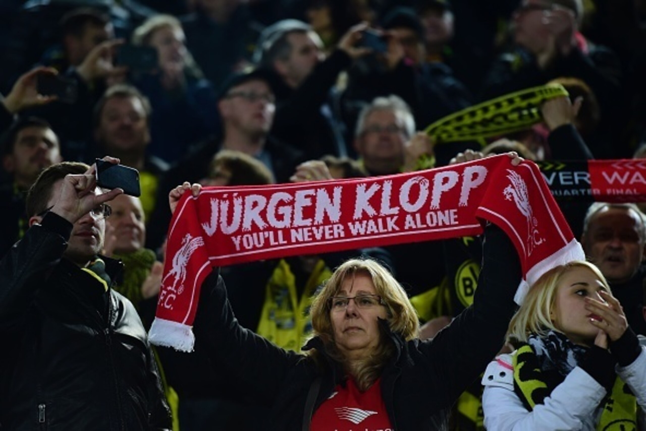 A fan holds up a Liverpool's German head coach Jurgen Klopp scarf prior to the UEFA Europe League quarter-final, first-leg football match Borussia Dortmund vs Liverpool FC in Dortmund, western Germany on April 7, 2016. / AFP / John MACDOUGALL        (Phot