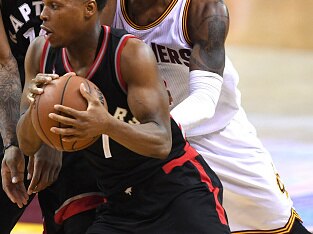 CLEVELAND, OH - MAY 17: Kyle Lowry #7 of the Toronto Raptors handles the ball against J.R. Smith #5 and Kyrie Irving #2 of the Cleveland Cavaliers in the third quarter in game one of the Eastern Conference Finals during the 2016 NBA Playoffs at Quicken Lo