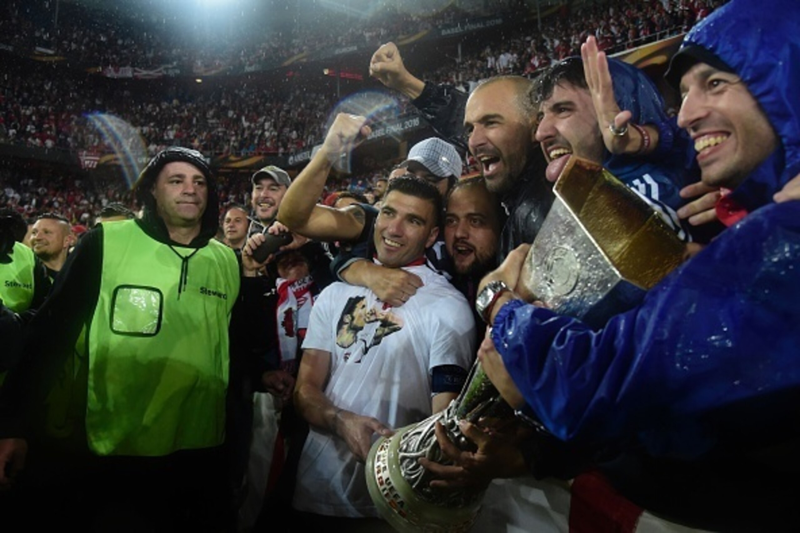 Sevilla's Spanish midfielder Jose Antonio Reyes holds the trophy as he celebrates with supporters after winning the UEFA Europa League final football match between Liverpool FC and Sevilla FC at the St Jakob-Park stadium in Basel, on May 18, 2016.  AFP PH