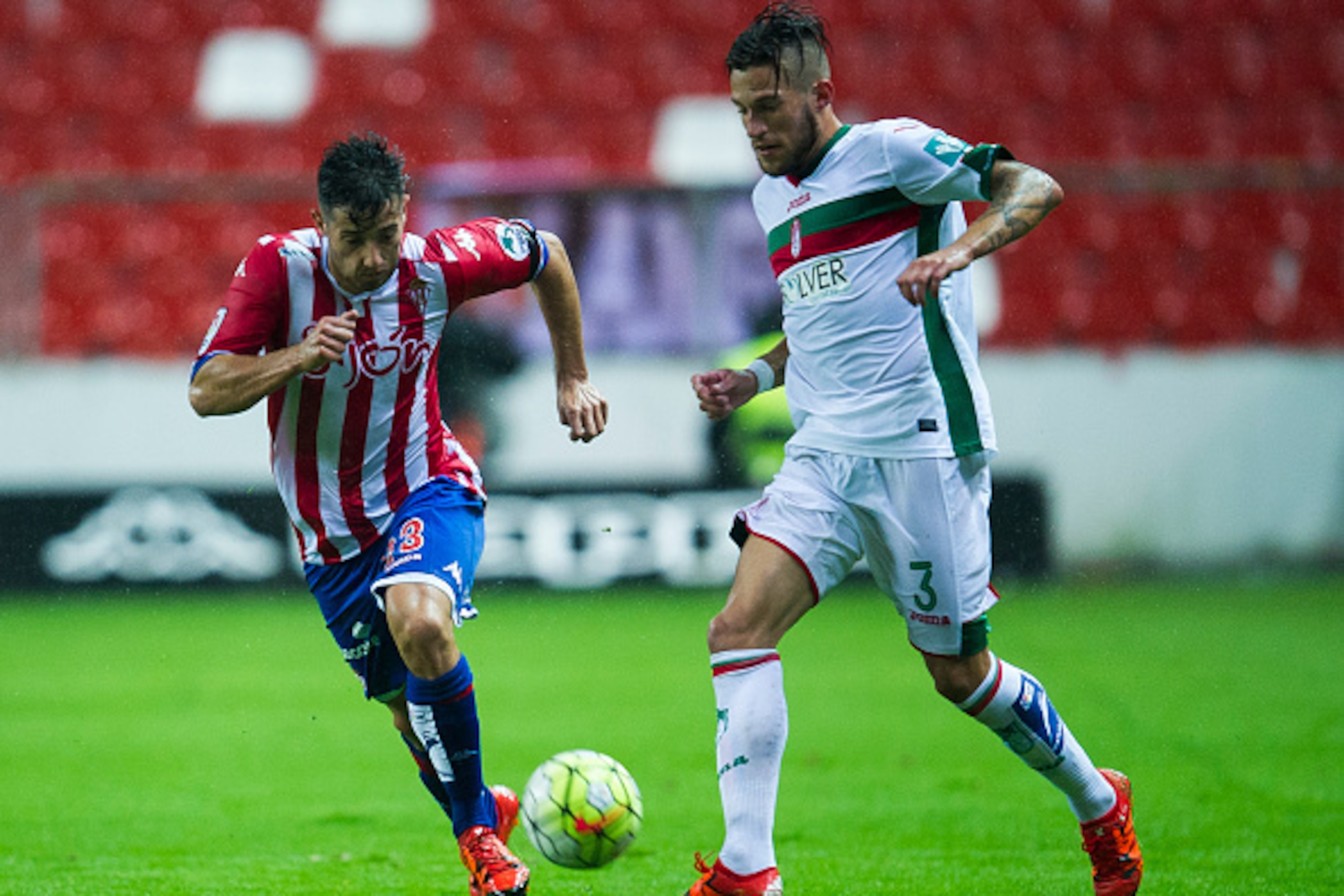 GIJON, SPAIN - OCTOBER 19: Cristiano Biraghi of Granada CF duels for the ball with Jony Rodriguez of Real Sporting de Gijon during the La Liga match between Real Sporting de Gijon and Granada CF at Estadio El Molinon on October 19, 2015 in Gijon, Spain.  
