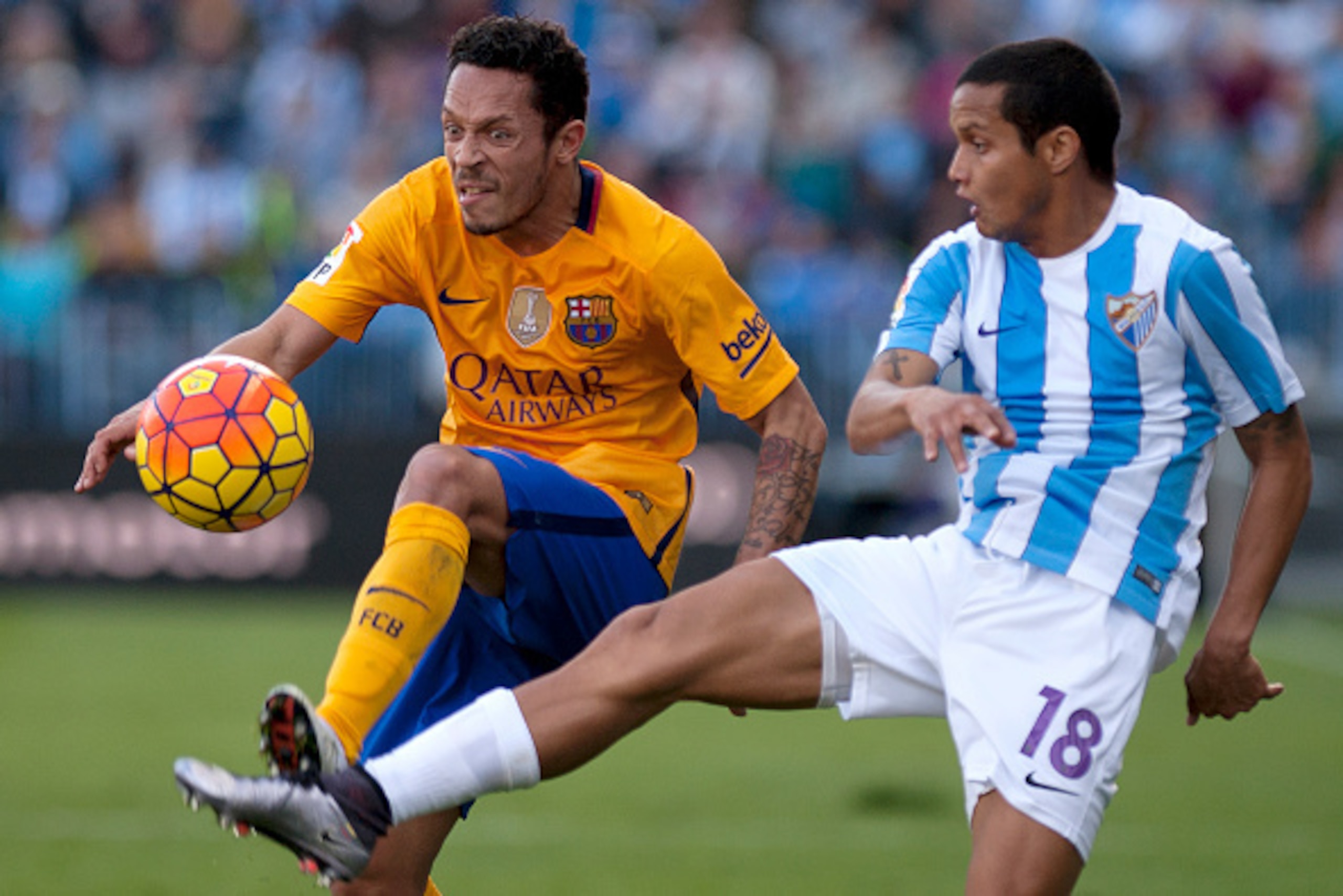 Barcelona's Brazilian defender Adriano (L) vies with Malaga's Venezuelan defender Roberto Jose Rosales during the Spanish league football match Malaga CF vs FC Barcelona at La Rosaleda stadium in Malaga on January 23, 2016.  AFP PHOTO / JORGE GUERRERO / A