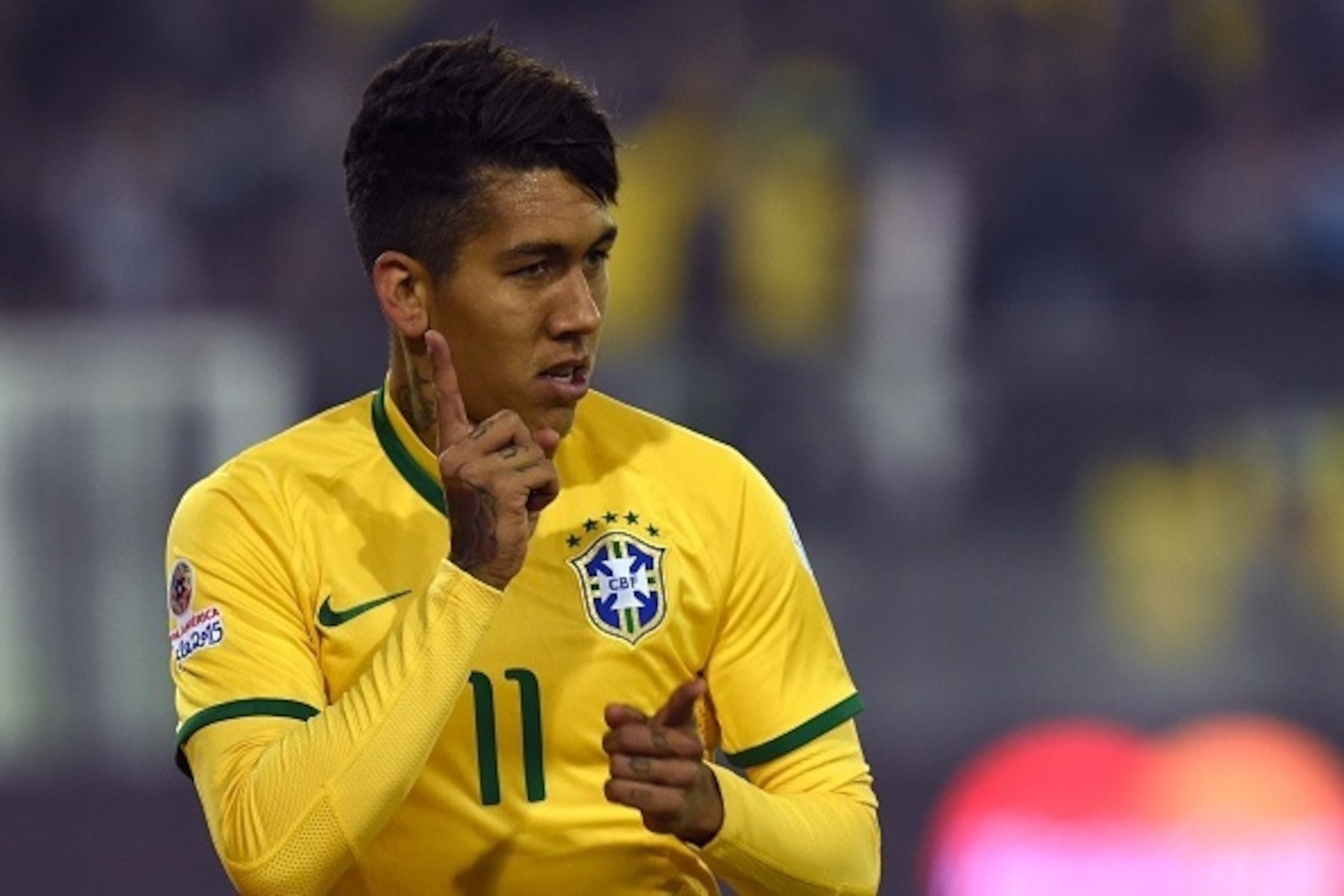 Brazil's forward Roberto Firmino celebrates after scoring the team's second goal against Venezuela during their 2015 Copa America football championship match, at the Estadio Monumental David Arellano in Santiago, on June 21, 2015.    AFP PHOTO / PABLO POR