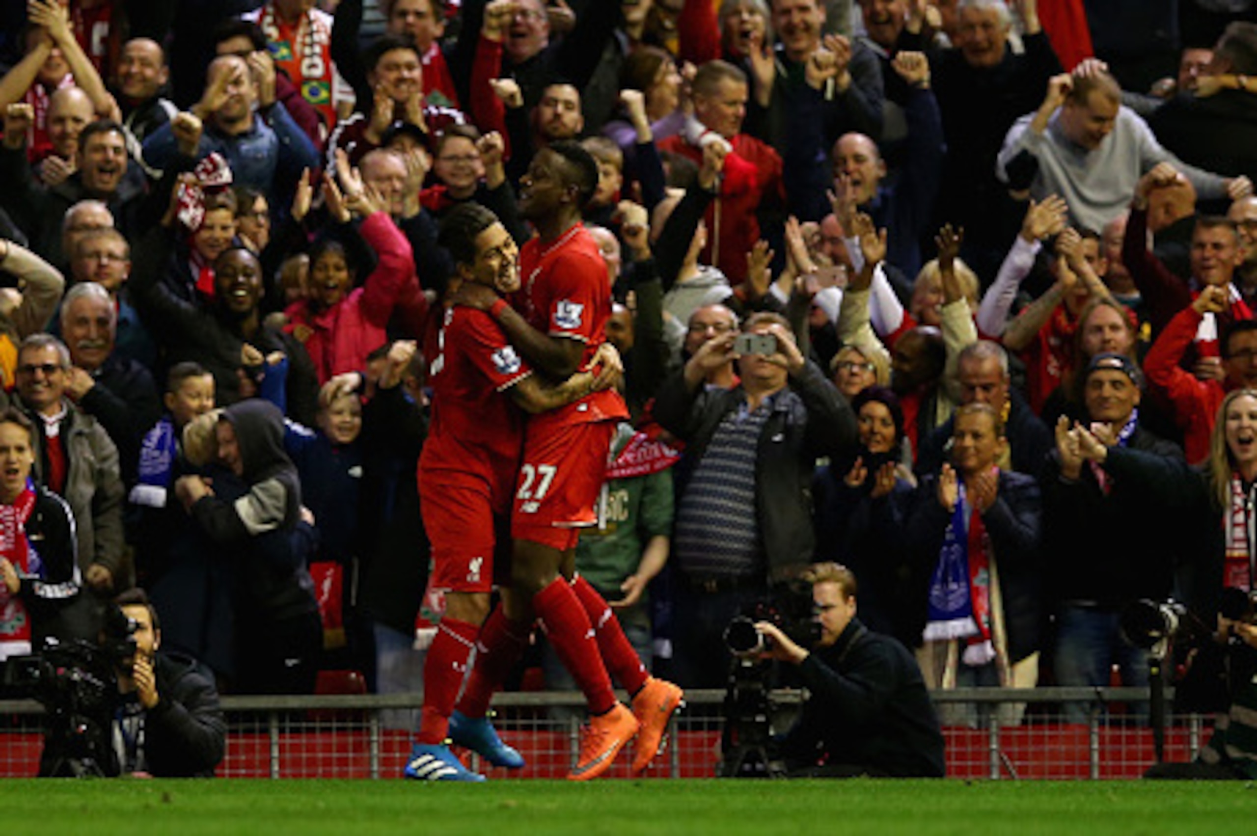LIVERPOOL, ENGLAND - APRIL 20:  Divock Origi of Liverpool celebrates with Roberto Firminho after scoring the opening goal during the Barclays Premier League match between Liverpool and Everton at Anfield, April 20, 2016, Liverpool, England  (Photo by Cliv