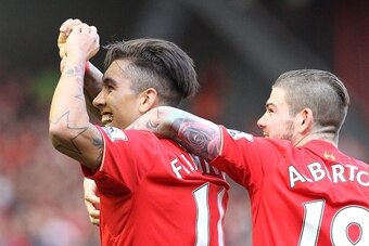 Liverpool's Brazilian midfielder Roberto Firmino (L) celebrates with teammates after scoring his team's second goal during the English Premier League football match between Liverpool and Watford at Anfield in Liverpool, north west England on May 8, 2016. 