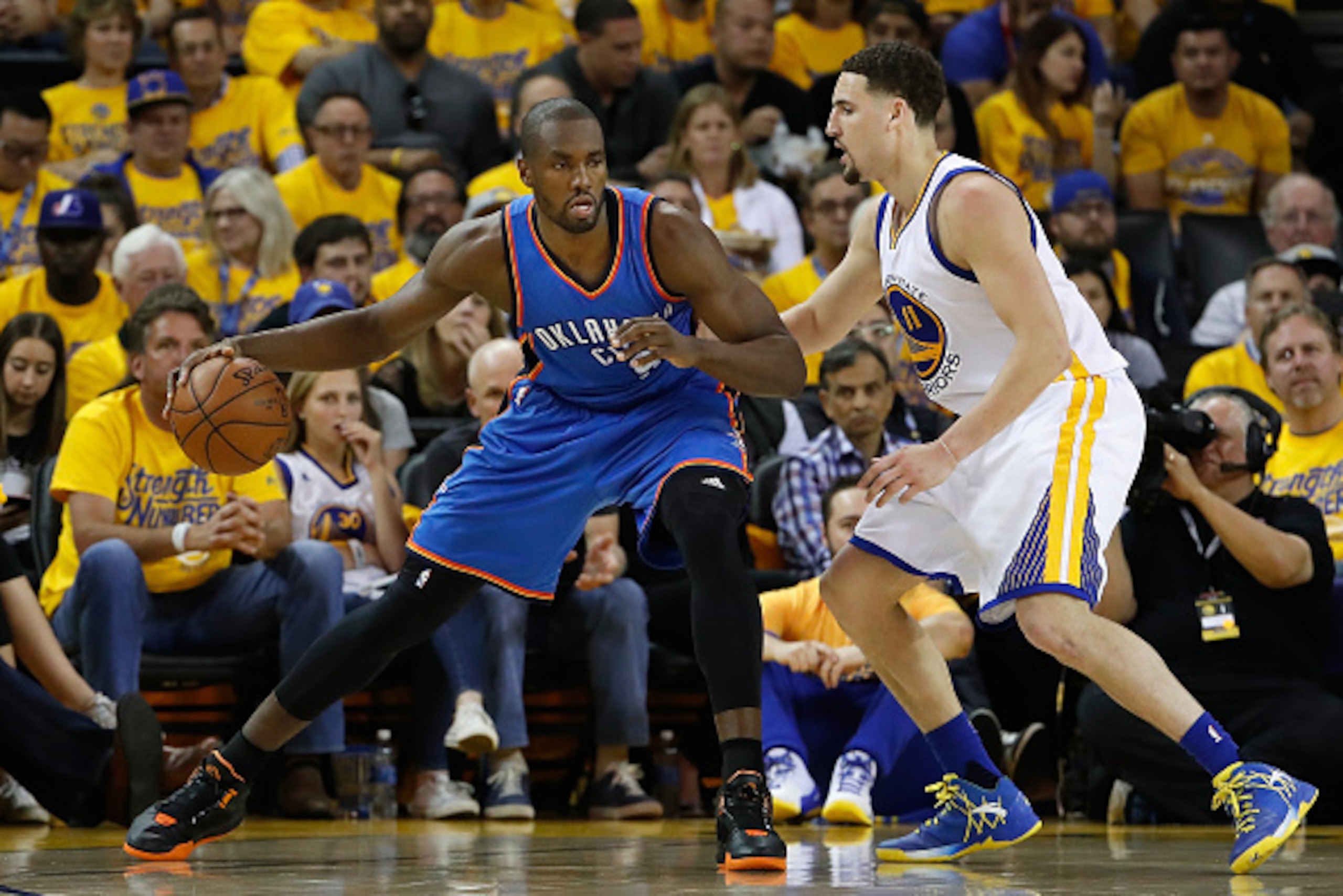 OAKLAND, CA - MAY 16:  Serge Ibaka #9 of the Oklahoma City Thunder handles the ball against Klay Thompson #11 of the Golden State Warriors during game one of the NBA Western Conference Finals at ORACLE Arena on May 16, 2016 in Oakland, California. The Thu