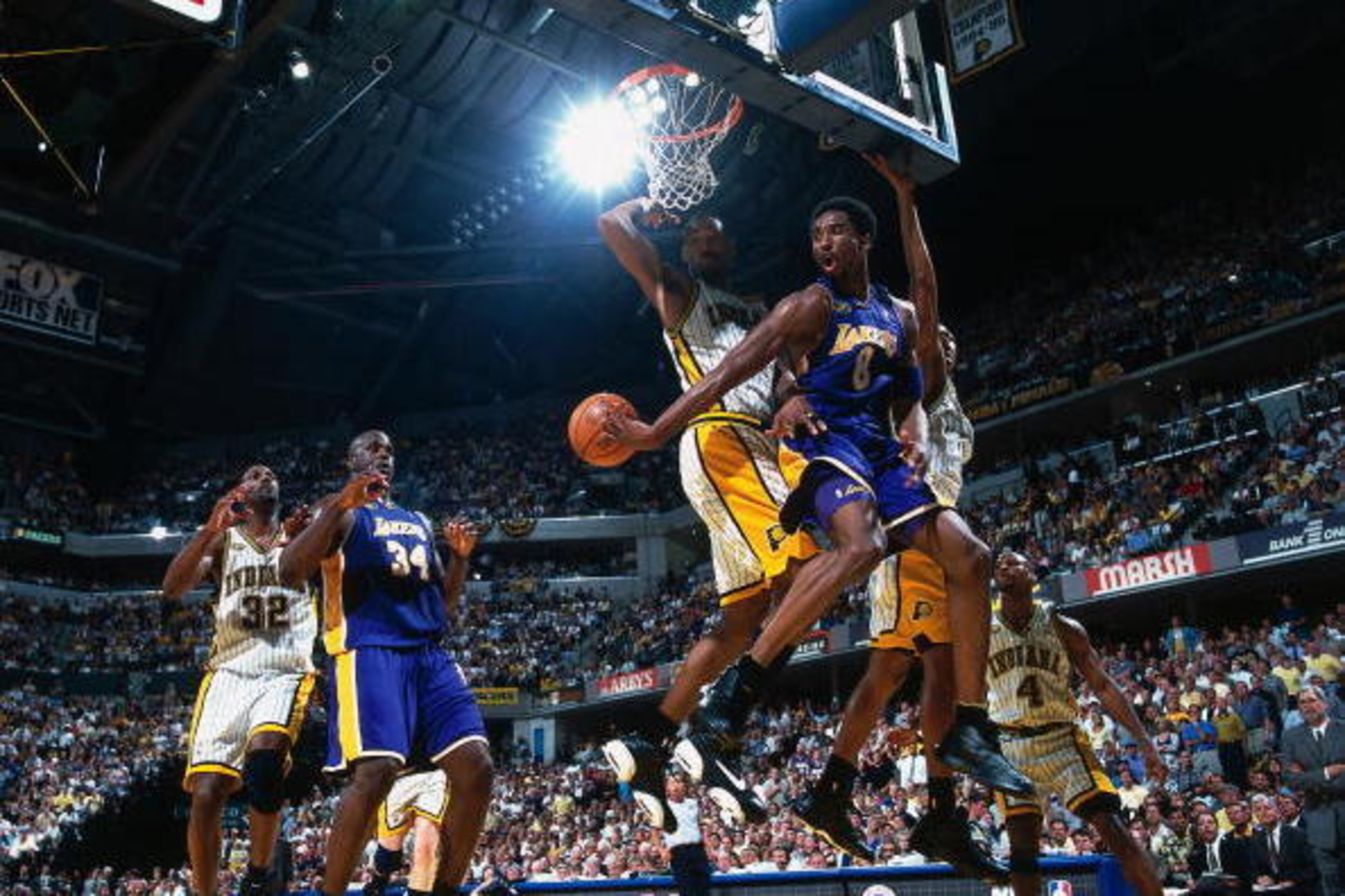 INDIANAPOLIS - 2001:  Kobe Bryant #8 passes to teammate Shaquille O'Neal #34 of the Los Angeles Lakers against Travis Best #4 of the Indiana Pacers during a game in 2000 at Conseco Field House in Indianapolis, Indiana.   NOTE TO USER:  User expressly ackn