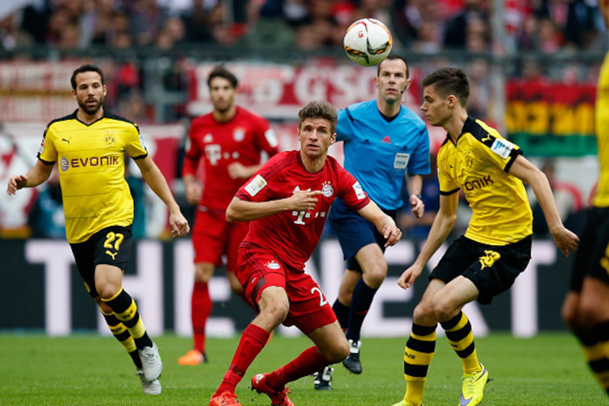 MUNICH, GERMANY - OCTOBER 04:  Gonzalo Castro (L) and Julian Weigl (R) of Borussia Dortmund challenge Thomas Mueller of Bayern Muenchen during the Bundesliga match between FC Bayern Muenchen and Borussia Dortmund at Allianz Arena on October 4, 2015 in Mun