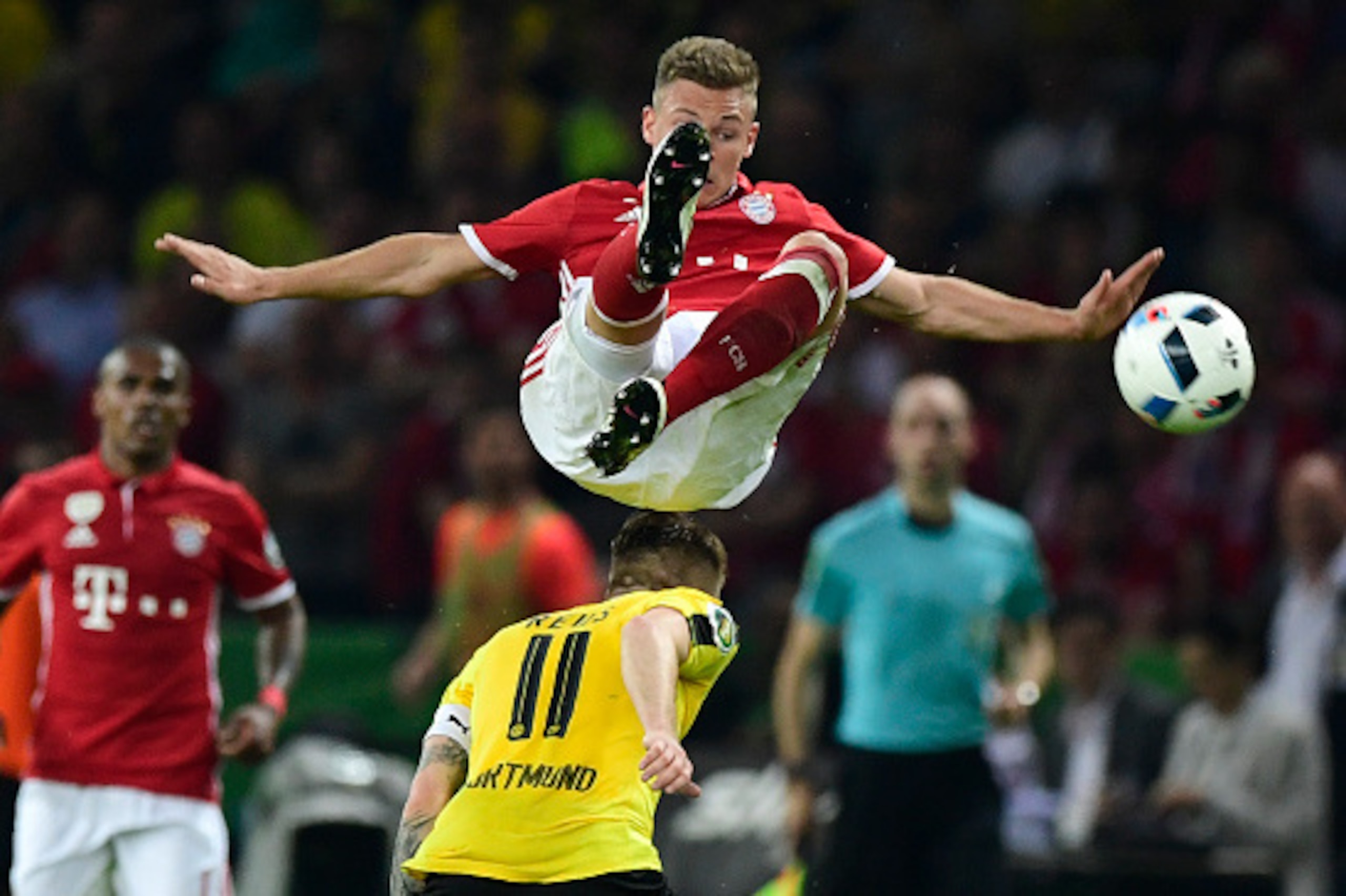 Bayern Munich's midfielder Joshua Kimmich (top) jumps over Dortmund's striker Marco Reus during the German Cup (DFB Pokal) final football match Bayern Munich vs Borussia Dortmund at the Olympic stadium in Berlin on May 21, 2016. / AFP / John MACDOUGALL / 