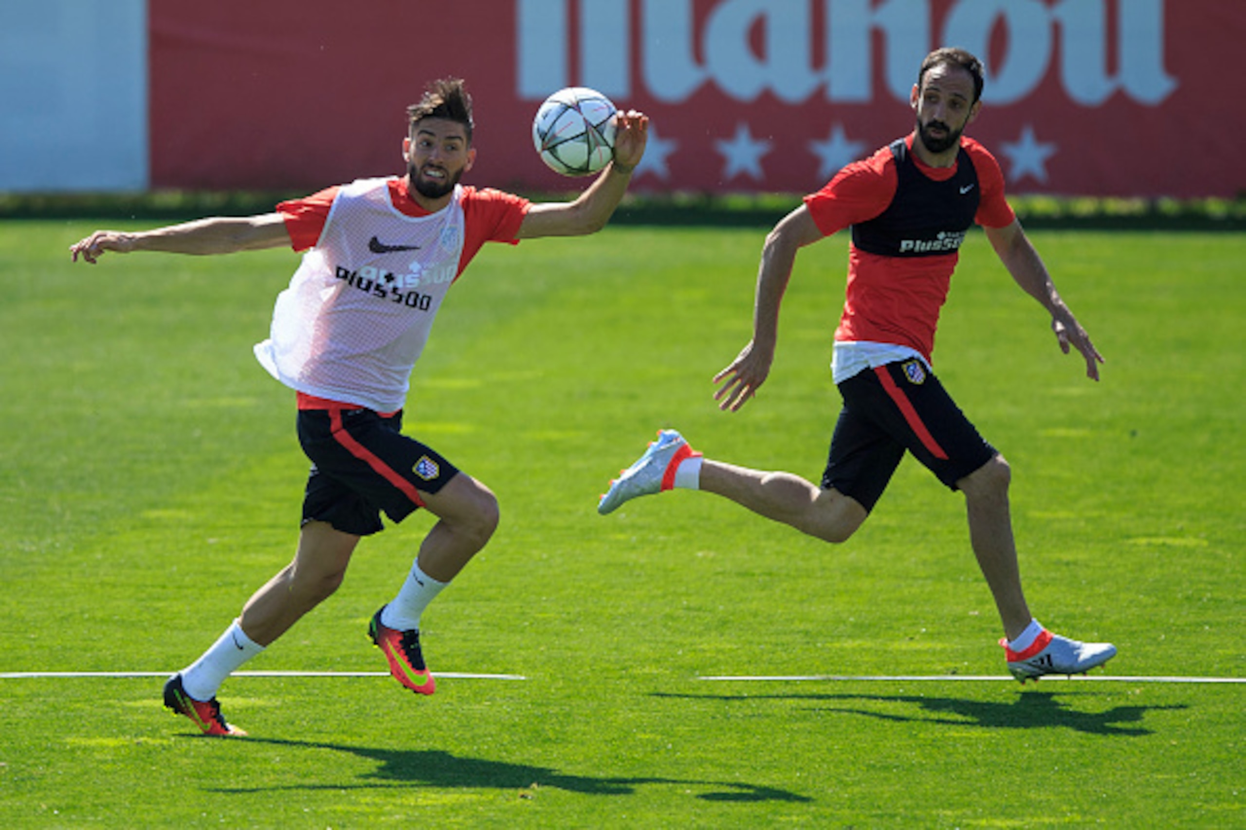 MADRID, SPAIN - MAY 21: Yannick Carrasco (L) of Atletico de Madrid competes for the ball with with teammate Juan Francisco Torres alias Juanfran (R) during the training session during the Club Atletico de Madrid Open Media Day ahead of the UEFA Champions 