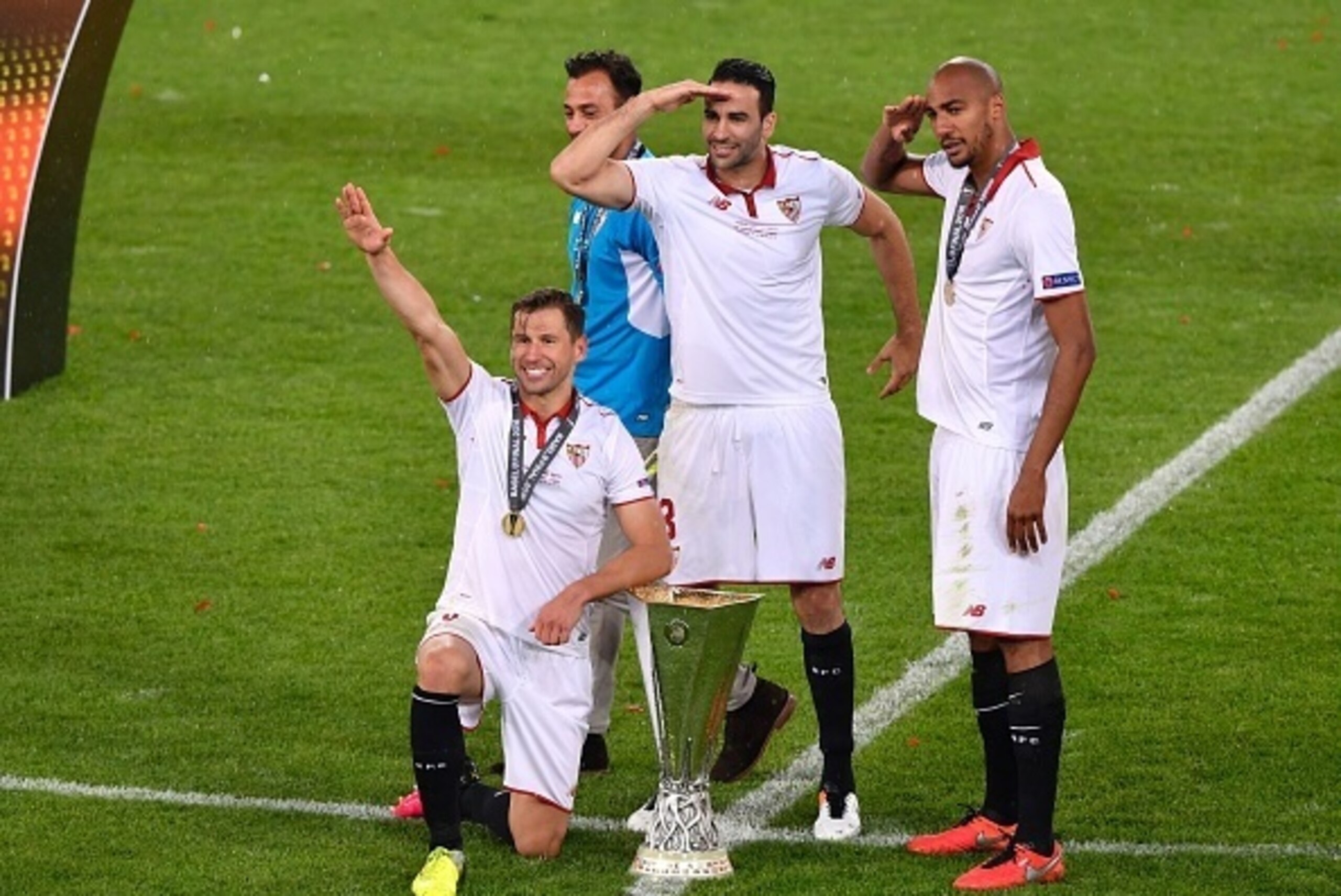 (L-R) Sevilla's Polish midfielder Grzegorz Krychowiak, Sevilla's French defender Adil Rami and Sevilla's French midfielder Steven N'Zonzi pose with the trophy as they celerbate winning  the UEFA Europa League final football match between Liverpool FC and 