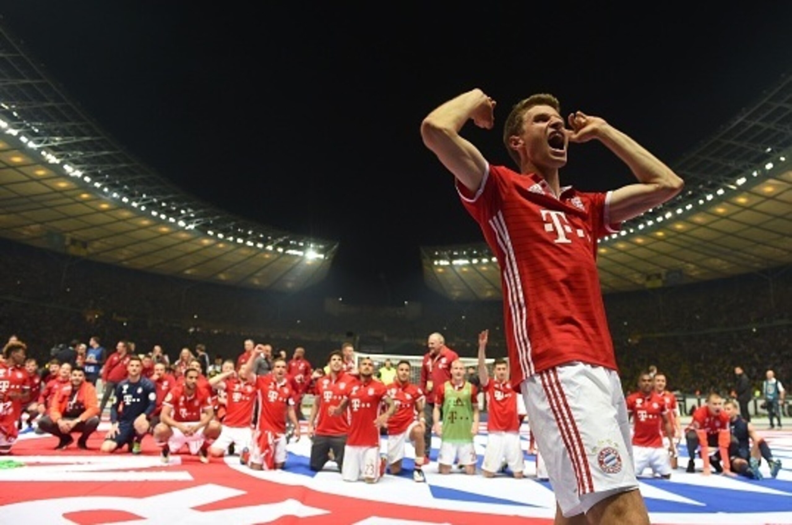 Bayern Munich's midfielder Thomas Mueller (R) and his teammates celebrate after defeating Dortmund in the penalty shootout of the German Cup (DFB Pokal) final football match Bayern Munich vs Borussia Dortmund at the Olympic stadium in Berlin on May 21, 20