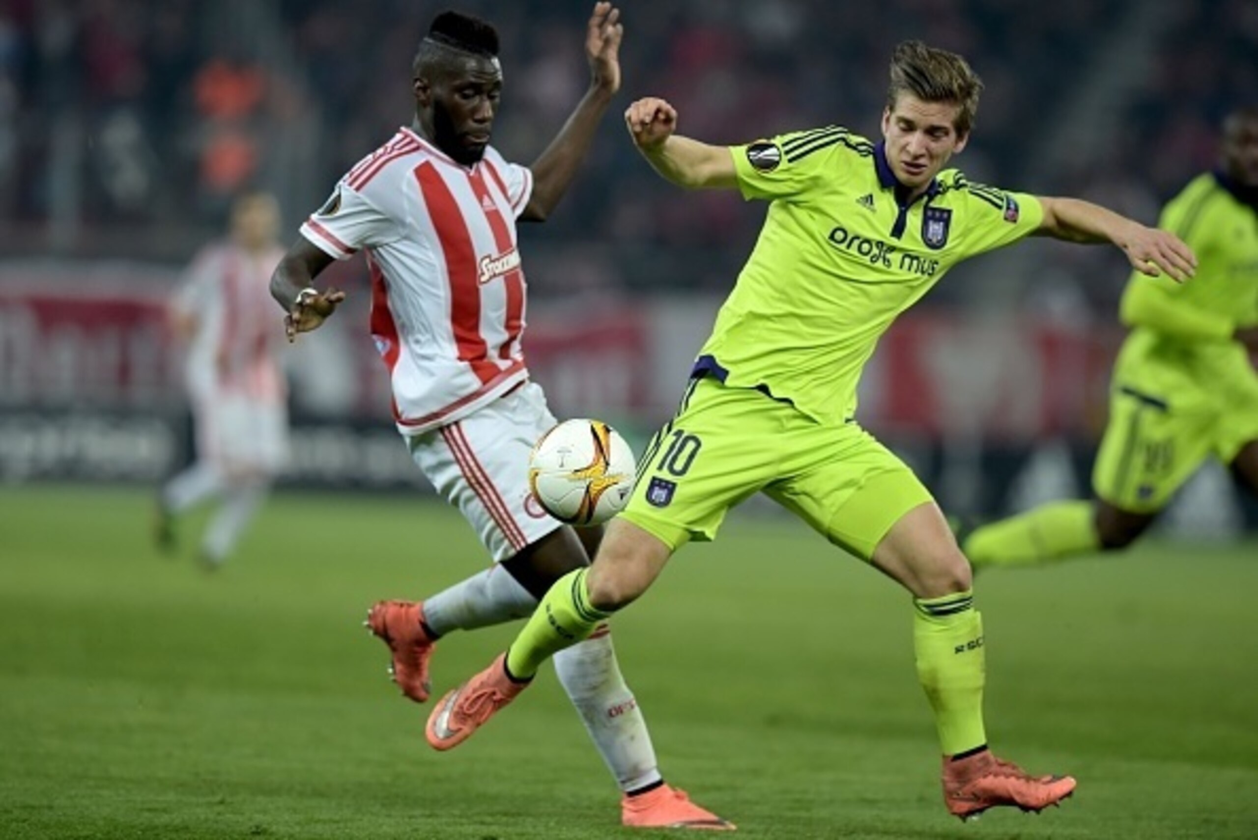 Olympiakos' Arthur Masuaku (L) fights for the ball with Anderlecht's Dennis Praet during the round of 32 Europa League football game Olympiakos vs Anderlecht at the Karaiskaki stadium in Athens on February 25, 2016.  / AFP / ARIS MESSINIS        (Photo cr