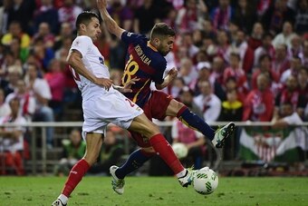 Barcelona's defender Jordi Alba (R) scores a goal past Sevilla's midfielder Vitoloduring the Spanish 'Copa del Rey' (King's Cup) final match FC Barcelona vs Sevilla FC at the Vicente Calderon stadium in Madrid on May 22, 2016. / AFP / PIERRE-PHILIPPE MARC