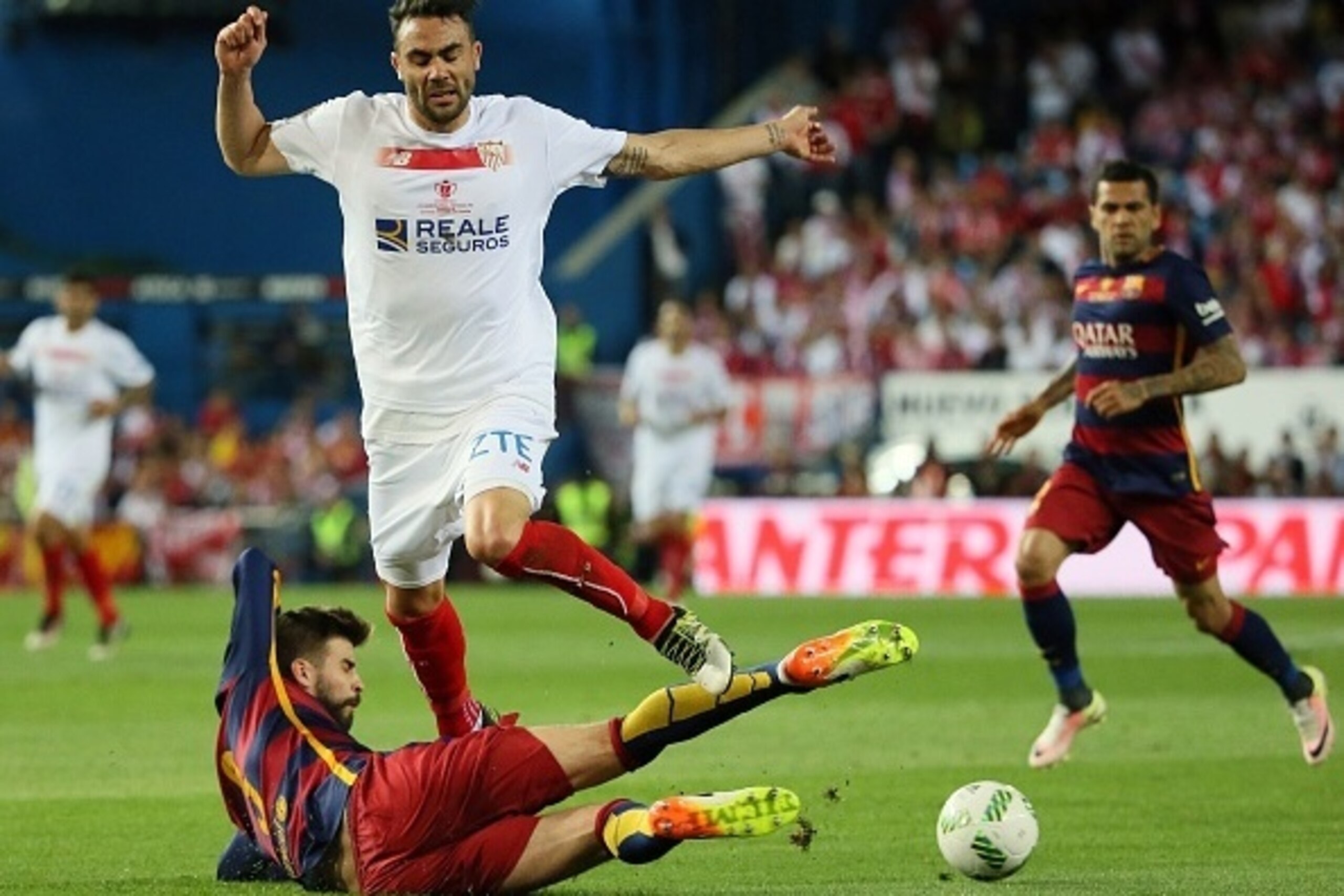 Sevilla's midfielder Vicente Iborra (Up) vies with Barcelona's defender Gerard Pique during the Spanish 'Copa del Rey' (King's Cup) final match FC Barcelona vs Sevilla FC at the Vicente Calderon stadium in Madrid on May 22, 2016. / AFP / CESAR MANSO      