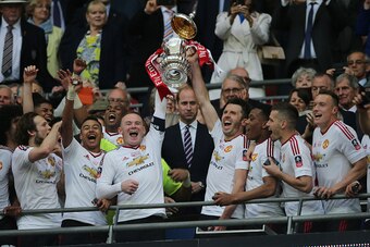 LONDON, ENGLAND - MAY 21:  Michael Carrick and Wayne Rooney of Manchester United lift the trophy following their 1-2 victory at the end of extra time during The Emirates FA Cup final match between Manchester United and Crystal Palace at Wembley Stadium on