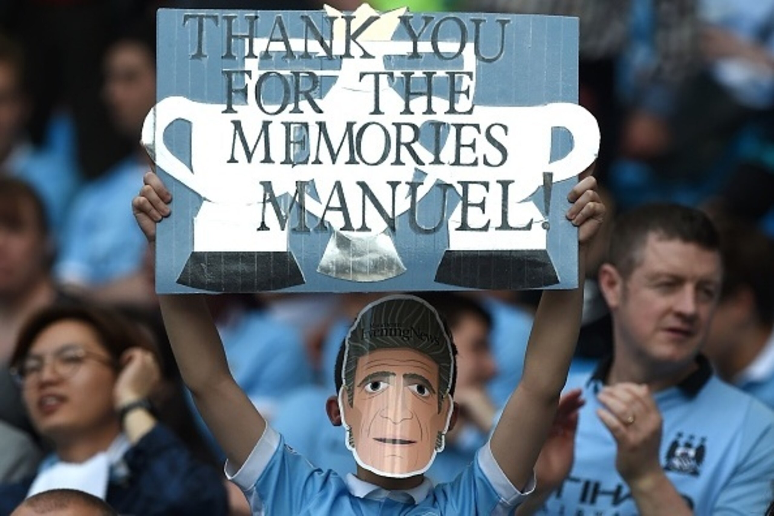 A Manchester City fan holds up a banner supporting Manchester City's Chilean manager Manuel Pellegrini during the English Premier League football match between Manchester City and Arsenal at the Etihad Stadium in Manchester, north west England, on May 8, 