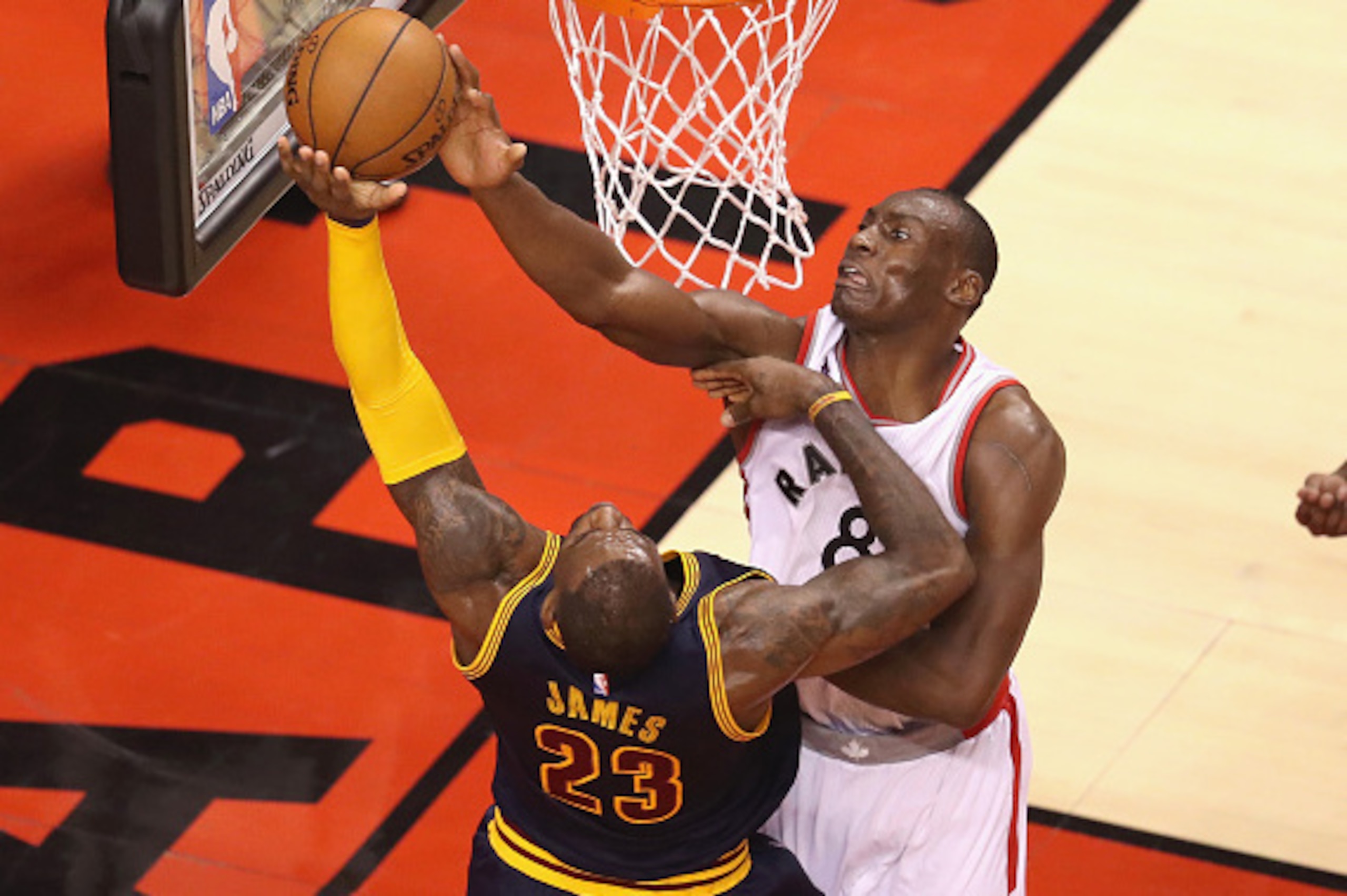 TORONTO, ON - MAY 21: Bismack Biyombo #8 of the Toronto Raptors blocks a shot by LeBron James #23 of the Cleveland Cavaliers and is called for a foul during the second half in game three of the Eastern Conference Finals during the 2016 NBA Playoffs at Ai TORONTO, ON - MAY 21: Bismack Biyombo #8 of the Toronto Raptors blocks a shot by LeBron James #23 of the Cleveland Cavaliers and is called for a foul during the second half in game three of the Eastern Conference Finals during the 2016 NBA Playoffs at Ai
