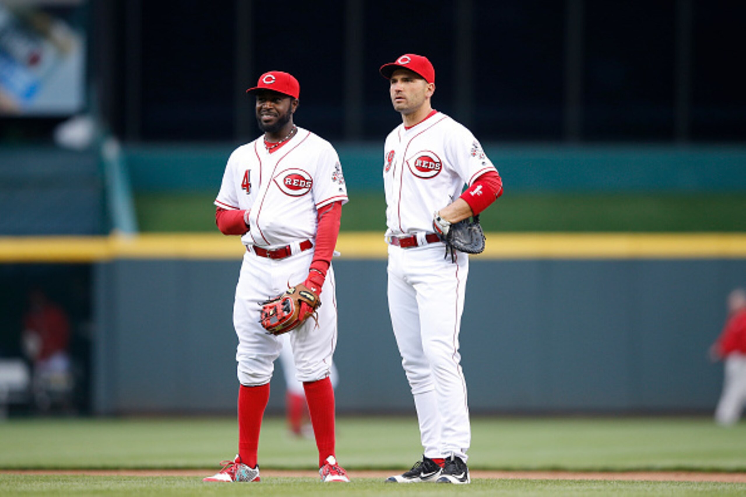 CINCINNATI, OHIO - APRIL 04: Brandon Phillips #4 and Joey Votto #19 of the Cincinnati Reds look on against the Philadelphia Phillies during the opening day game at Great American Ball Park on April 4, 2016 in Cincinnati, Ohio. The Reds defeated the Philli