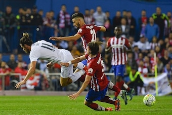 Real Madrid's Welsh forward Gareth Bale (L) falls past Atletico Madrid's Belgian midfielder Yannick Ferreira Carrasco (C) and Atletico Madrid's Brazilian defender Filipe Luis during the Spanish league football match Club Atletico de Madrid vs Real Madrid 