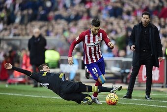 Atletico Madrid's Belgian midfielder Yannick Ferreira Carrasco (C) vies with Sevilla's Uruguayan midfielder Sebastian Cristoforo (L) next to Atletico Madrid's Argentinian coach Diego Simeone during the Spanish league football match Club Atletico de Madrid
