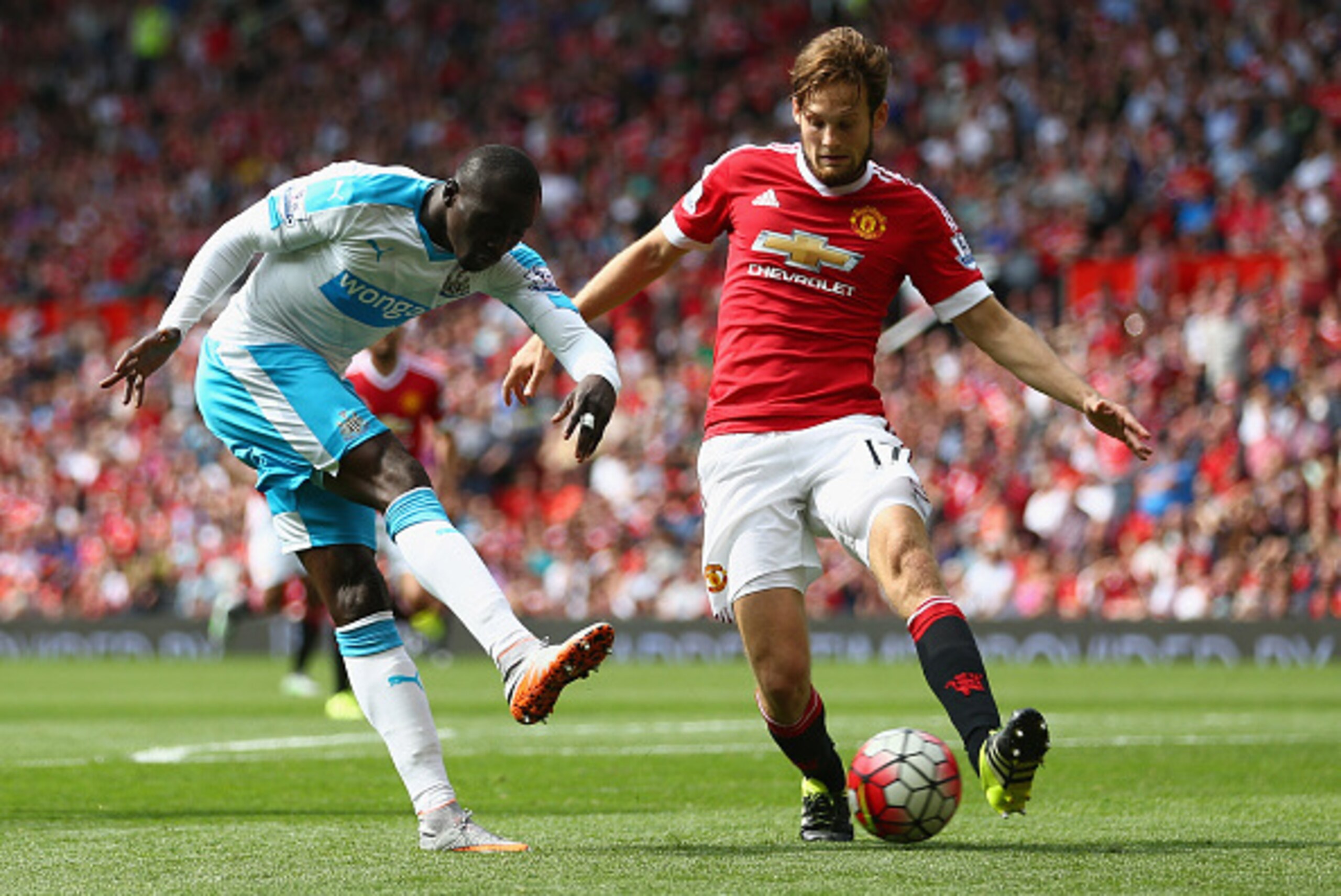MANCHESTER, ENGLAND - AUGUST 22:  Papiss Demba Cisse of Newcastle United and Daley Blind of Manchester United compete for the ball during the Barclays Premier League match between Manchester United and Newcastle United at Old Trafford on August 22, 2015 i