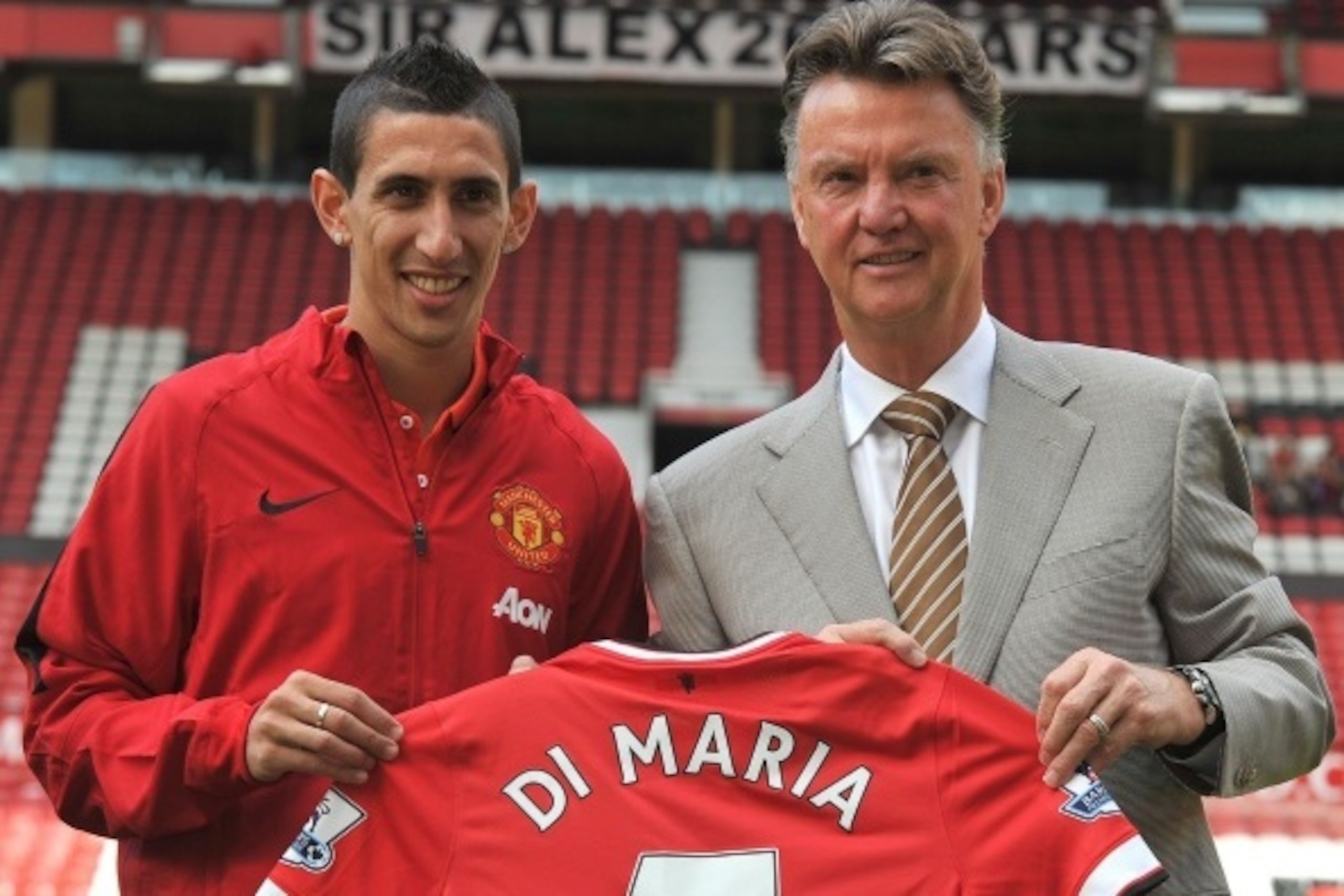 Manchester United's Dutch manager Louis van Gaal (R) and Manchester United's newly-signed Argentinian midfielder Angel di Maria (L) pose with his number 7 shirt during an official presentation on the pitch at Old Trafford in Manchester, north-west England