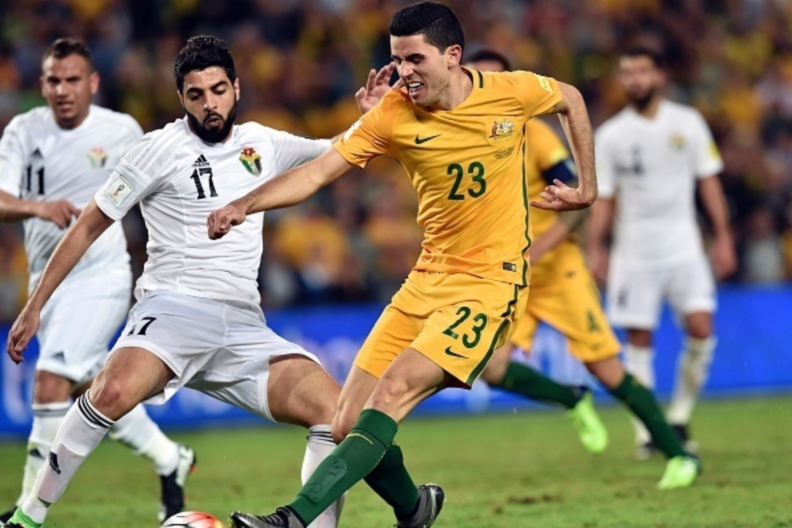 Tom Rogic (R) of Australia kicks the ball for a goal as Jordan's Oday Zahran (L0 tries to block him during the World Cup Asian qualifier football match between Australia and Jordan in Sydney on March 29, 2016.

 / AFP / SAEED KHAN        (Photo credit sho