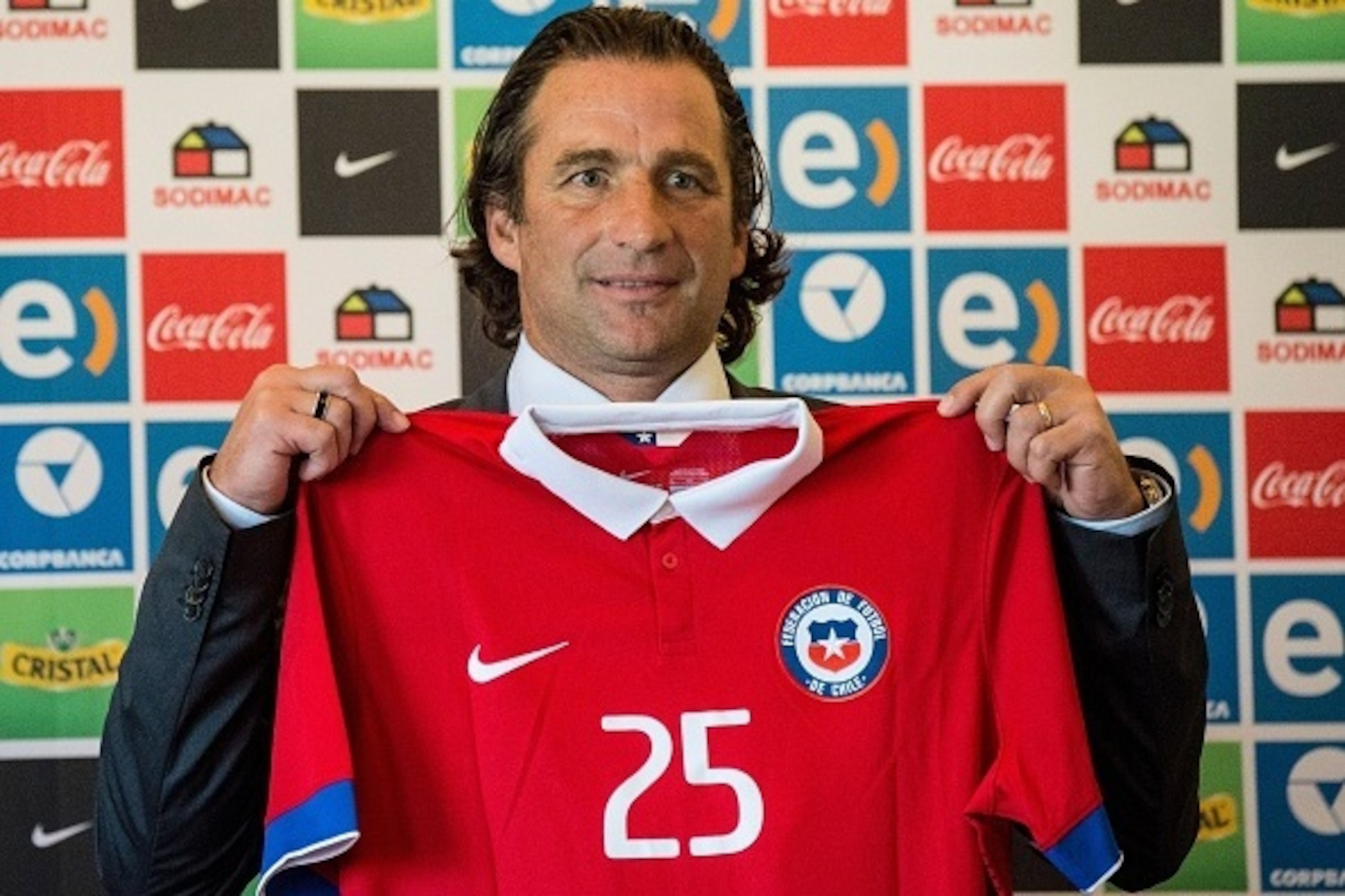 Argentinian-Spanish football coach Juan Antonio Pizzi shows a Chilean national football team jersey before a press conference in Santiago, on February 5, 2016.  Pizzi is Chile's new coach, replacing Argentinian Jorge Sampaoli.   AFP PHOTO MARTIN BERNETTI 