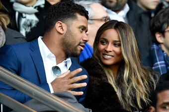 The Seattle Seahawks' US quarterback Russell Wilson (L) speaks to his girlfriend US singer Ciara during the French L1 football match between Paris Saint-Germain (PSG) and Montpellier (MHSC) on March 5, 2016, at the Parc des Princes stadium in Paris. / AFP
