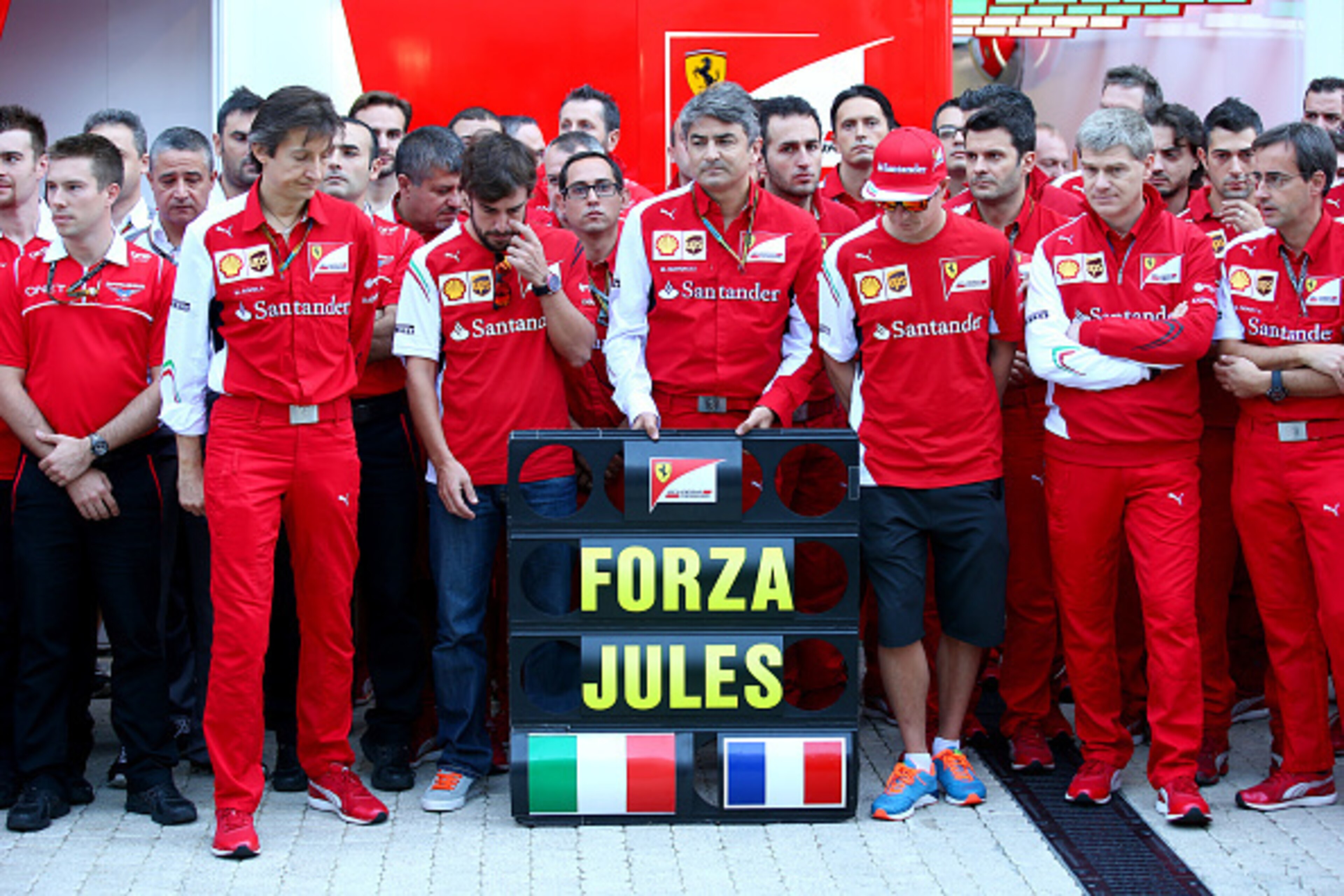 SOCHI, RUSSIA - OCTOBER 12:  Members of the Ferrari and Marussia teams, including Fernando Alonso, Kimi Raikkonen and Ferrari Team Principal Marco Mattiacci, pay tribute to Jules Bianchi of France and Marussia in the paddock following his accident at Suzu