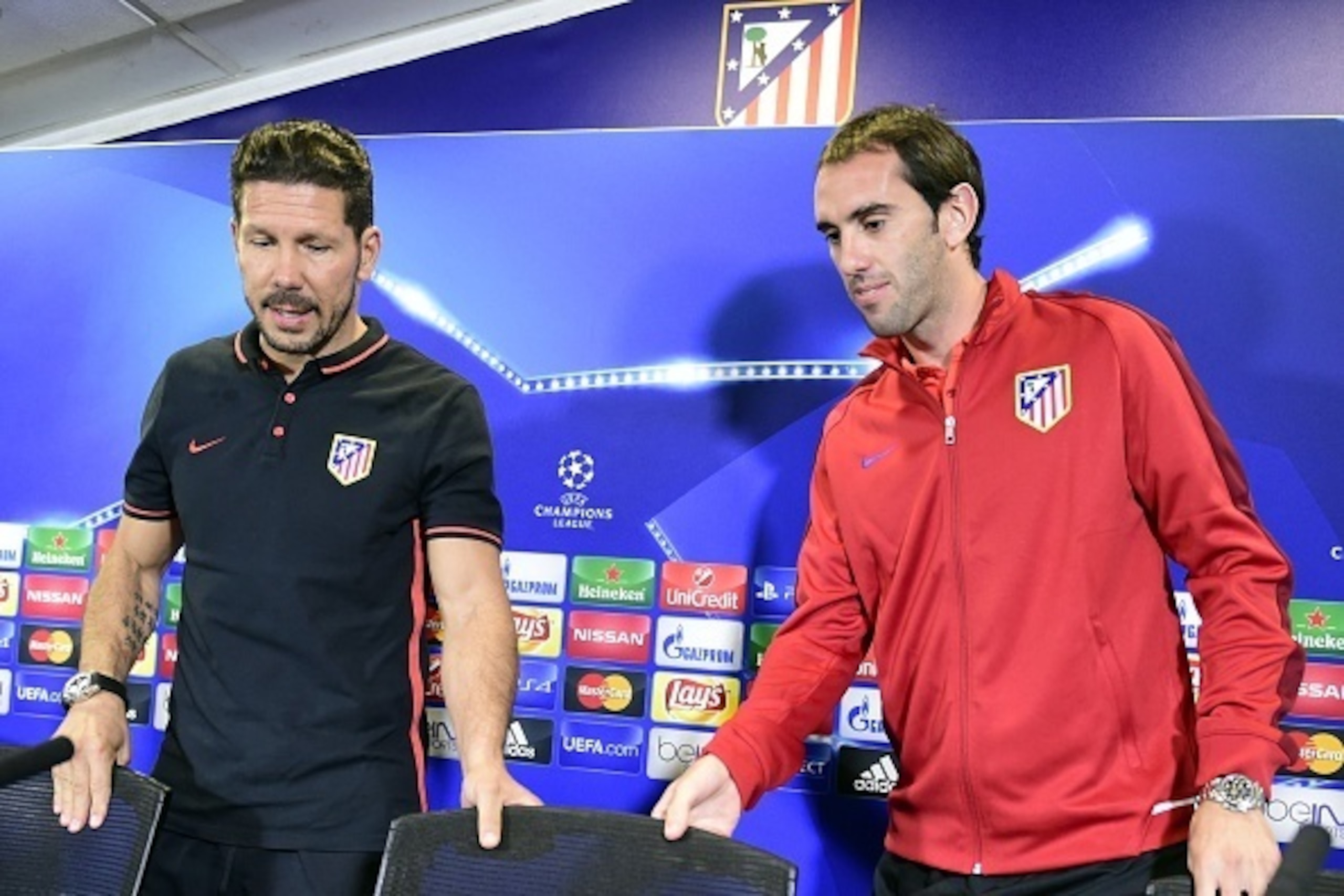 Atletico Madrid's Argentinian coach Diego Simeone (L) and Atletico Madrid's Uruguayan defender Diego Godin arrive to give a press conference at Vicente Calderon stadium in Madrid on September 29, 2015 on the eve of their UEFA Champions League football mat