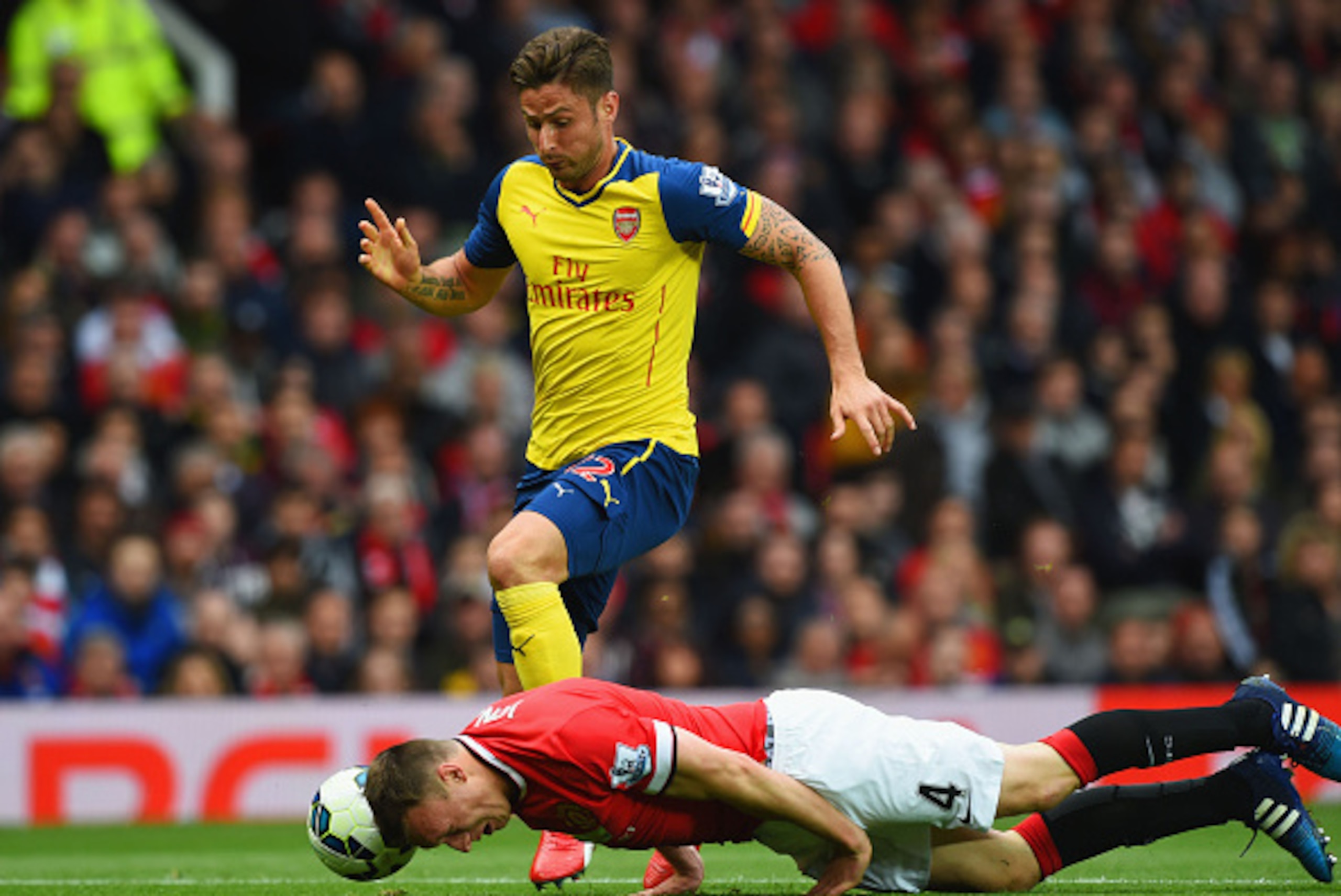 MANCHESTER, ENGLAND - MAY 17:  Phil Jones of Manchester United heads the ball clear of Olivier Giroud of Arsenal during the Barclays Premier League match between Manchester United and Arsenal at Old Trafford on May 17, 2015 in Manchester, England.  (Photo