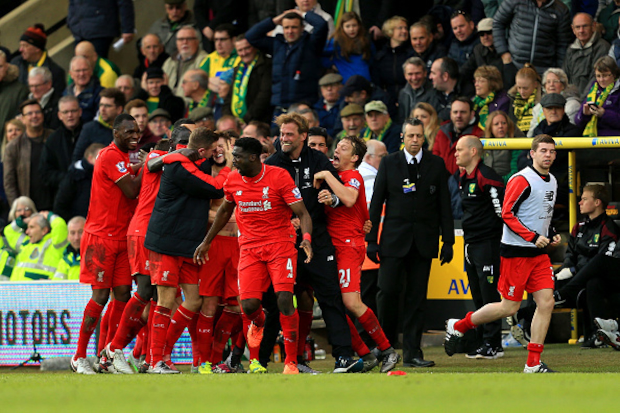 NORWICH, ENGLAND - JANUARY 23:  Adam Lallana (C) of Liverpool ceelbrates scoring his team's fifth goal with his team mates and manager Jurgen Klopp during the Barclays Premier League match between Norwich City and Liverpool at Carrow Road on January 23, 2