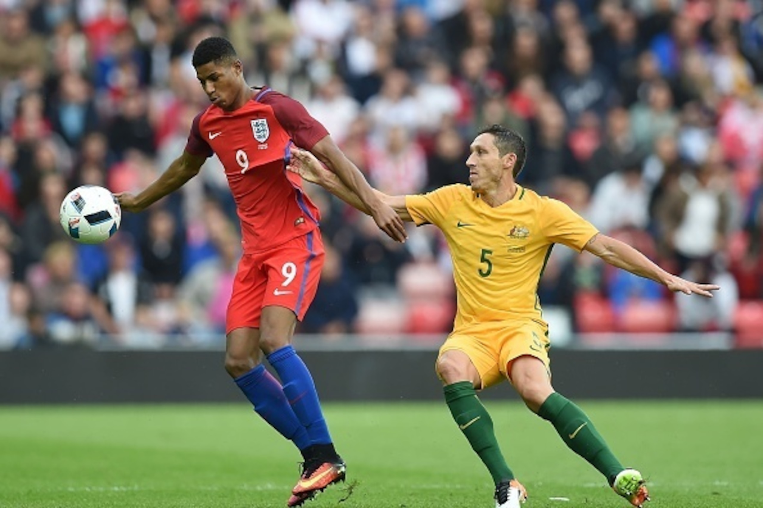 England's striker Marcus Rashford (L) vies for the ball against Australia's Mark Milligan during the International friendly football match between England and Australia at the Stadium of Light in Sunderland, north east England, on May 27, 2016. / AFP / PA