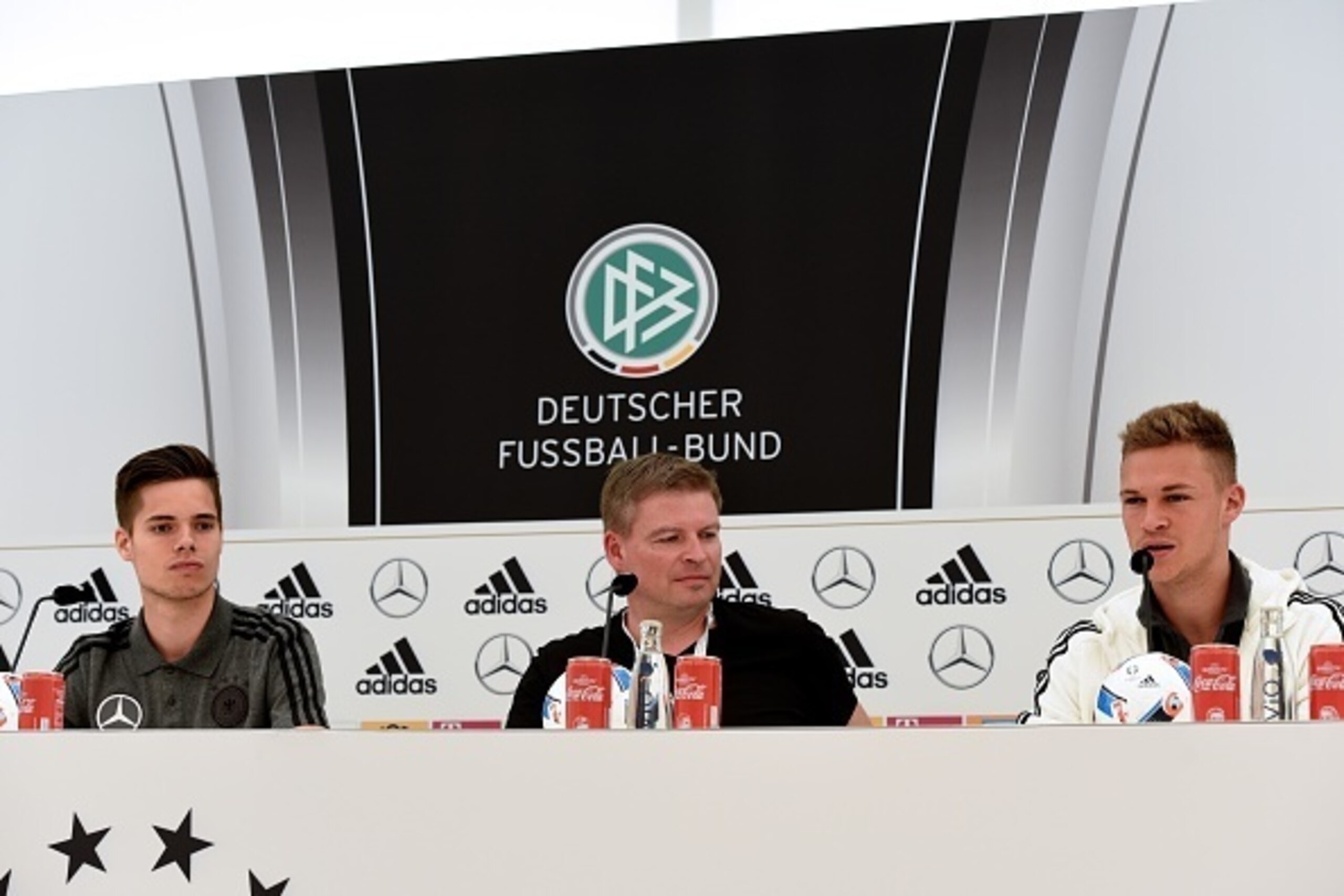Germany's defender Joshua Kimmich (R), Germany's defender Julian Weigl and Germany's national football team press officer Jens Grittner give a press conference on the sideline of the team's preparation for the upcoming Euro 2016 European football champion