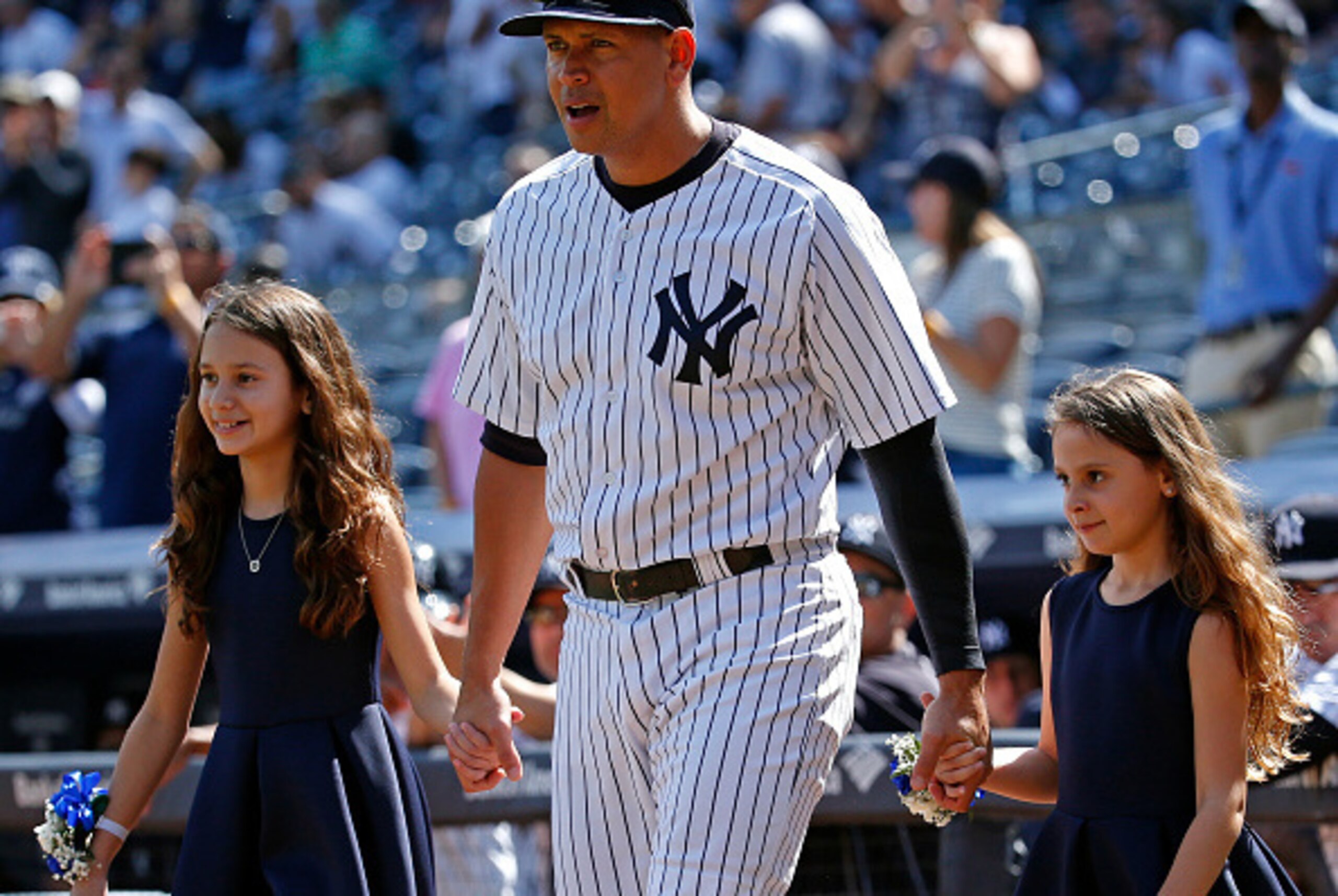 NEW YORK, NY - SEPTEMBER 13: Alex Rodriguez #13 of the New York Yankees and his daughters, Natasha and Ella, walk onto the field for a pregame ceremony celebrating Rodriguez's 3,000th career hit prior to taking on the Toronto Blue Jays at Yankee Stadium o