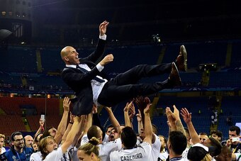 TOPSHOT - Real Madrid's French coach Zinedine Zidane is lifted by his players after Real Madrid won the UEFA Champions League final football match between Real Madrid and Atletico Madrid at San Siro Stadium in Milan, on May 28, 2016. / AFP / PIERRE-PHILIP